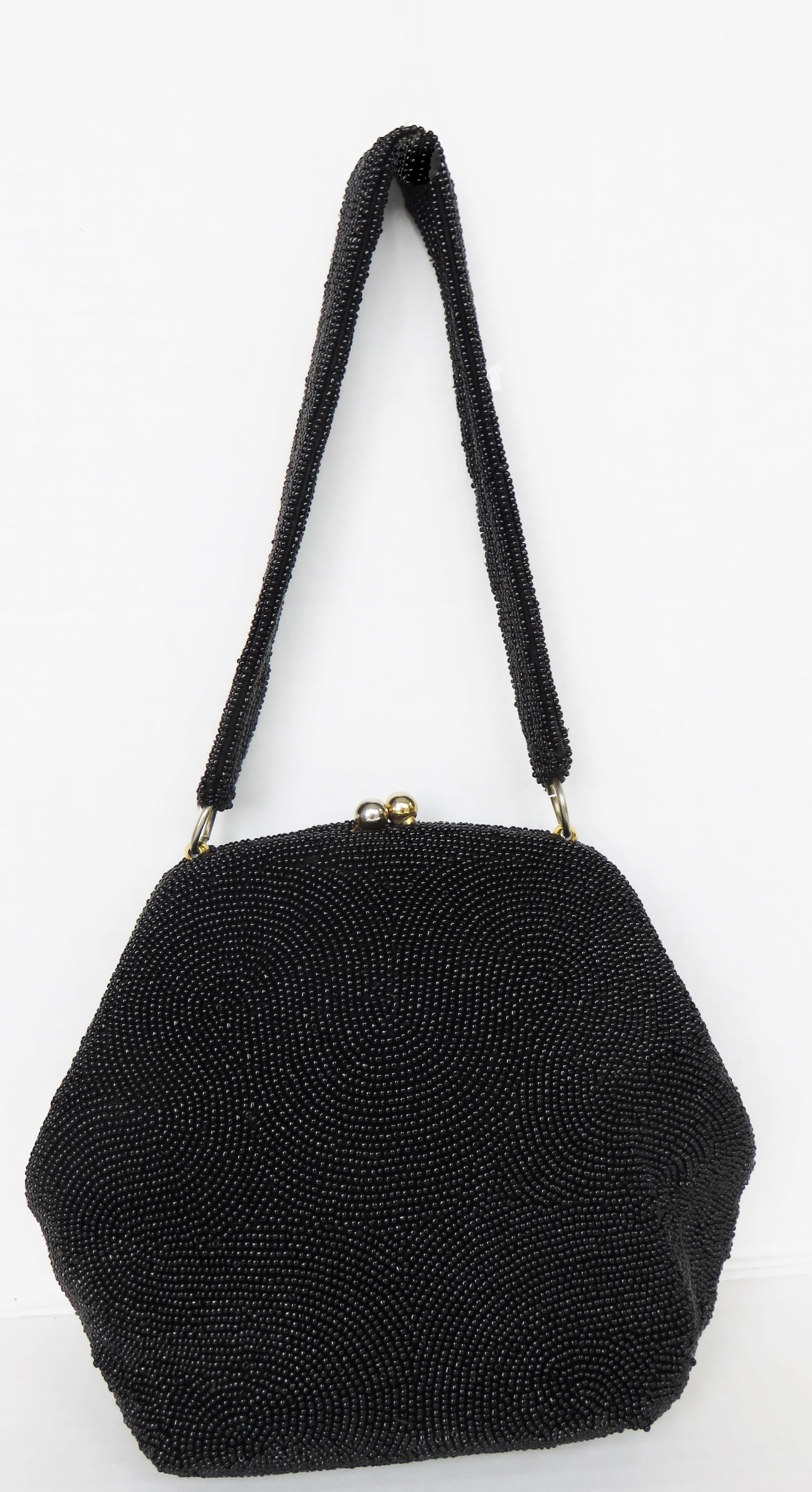 A gorgeous black glass seed beaded handbag in a great wave pattern by Josef.  It has a top handle, silk lining with a pocket and a gold clasp top closure.

Height  8