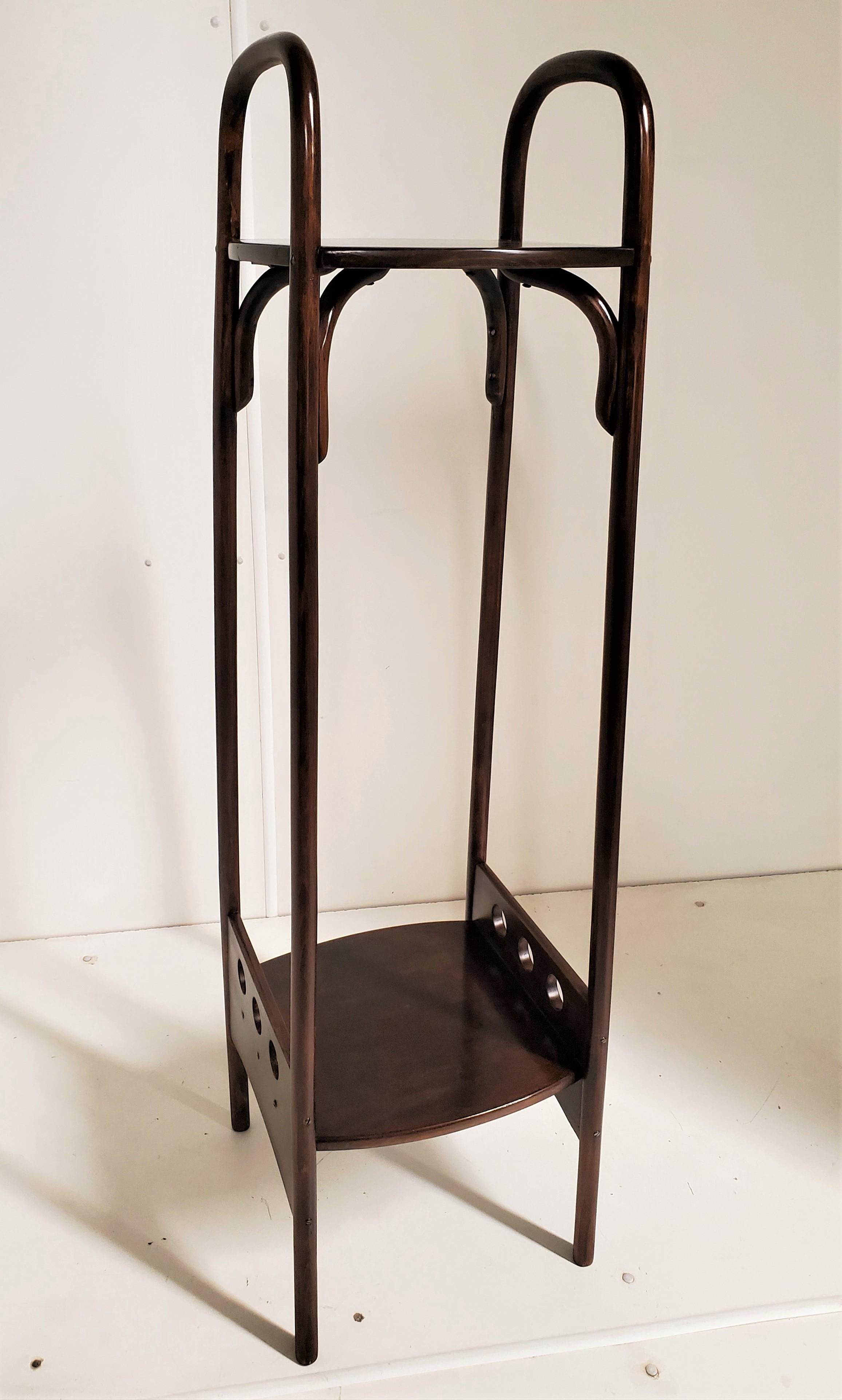 Josef Hoffman (designer) & Thonet (manufacturer) (1870-1956)
Plant holder in stained and polished beechwood with double curved arms extending the full length of the stand and culminating in a stretcher shelf with decorative openwork surround typical