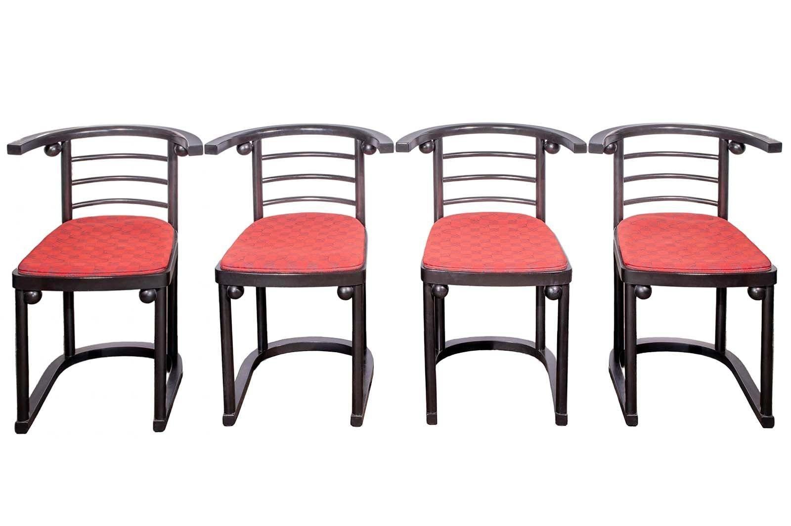 This vintage set made in the 1990's showcases the innovative style of Josef Hoffman, a renowned architect and designer of the early 20th century. The set consists of stunning ebonized round coffee table and four red upholstered chairs. 
The chairs'