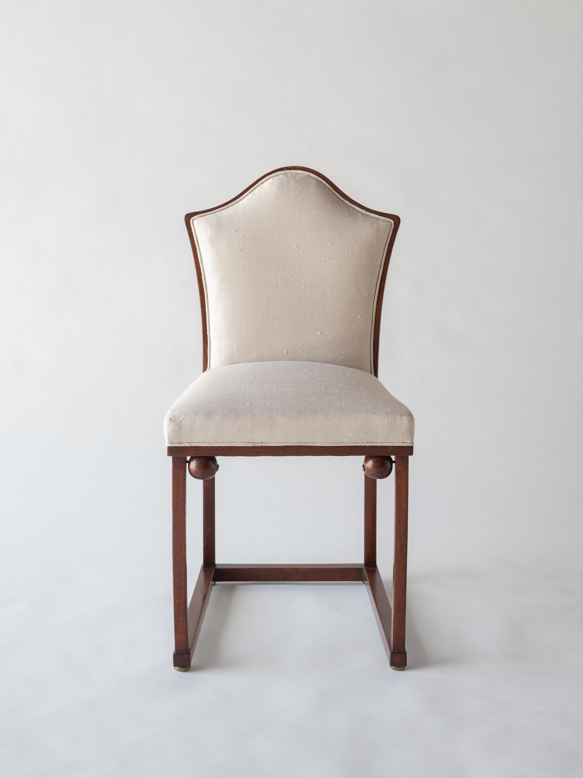 A Vienna Secessionist bentwood chair with upholstered back and seat. Gracefully sloped bell-shaped back gives way to a comfortable upholstered back and seat. Corner ball enforcement details (a signature of Hoffmann) decorate the chair's front legs.
