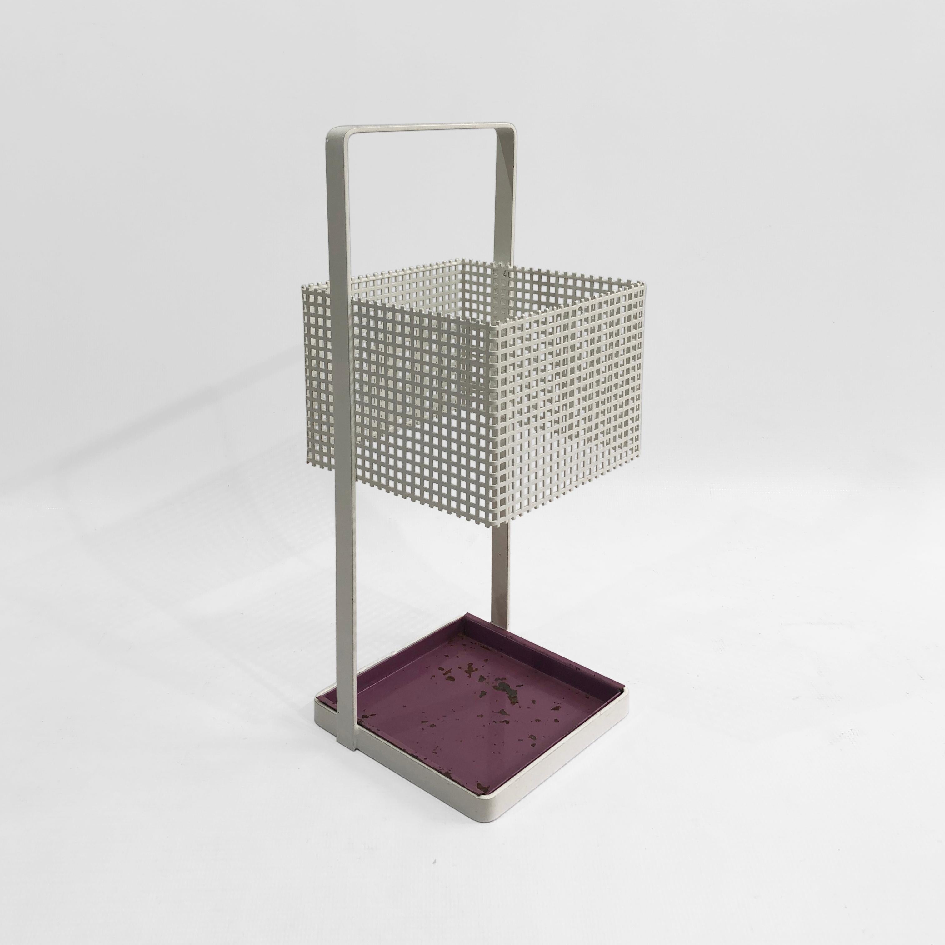 This modernist square umbrella stand of white powder-coated metal is a rare design Classic, from the renowned Josef Hoffmann for Bieffeplast. A square basket, with hundred of tiny square holes, is suspended from a white frame. At the base is a rich