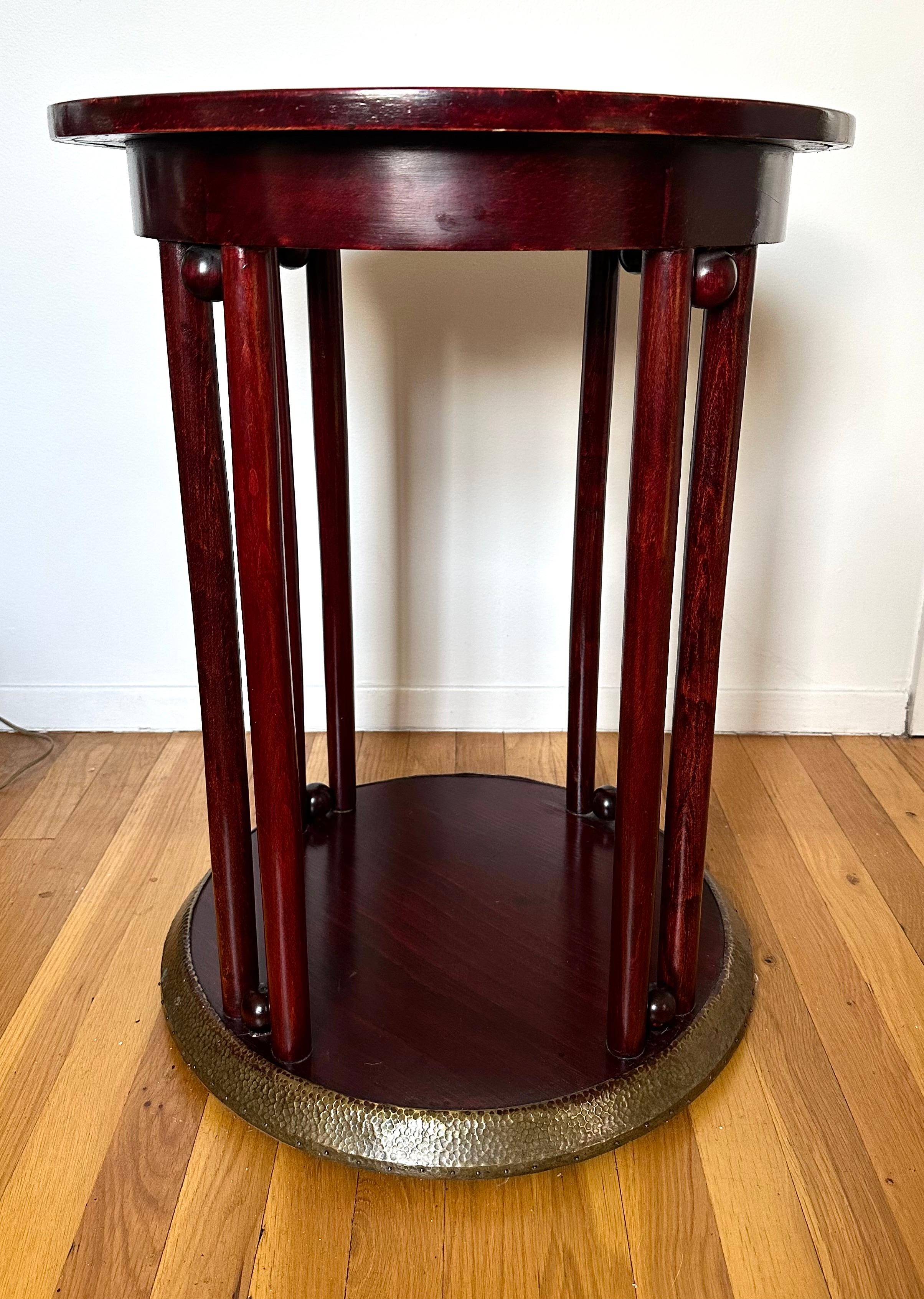 Nice early example of the iconic cafe table, designed in 1907 for the Fledermaus cabaret in Vienna. This example stands out due to the hand-hammered brass top and lower cladding.  The base is a red stained beechwood. 