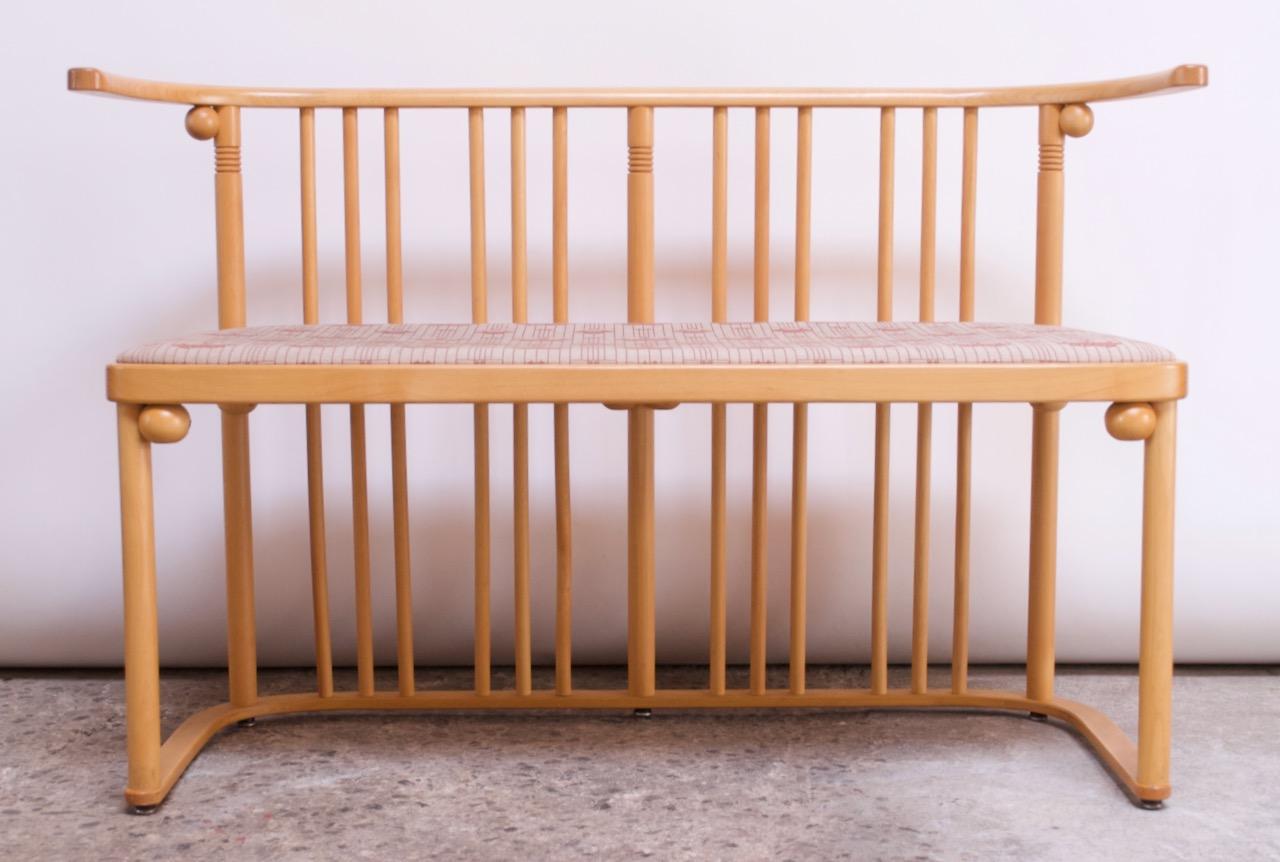 Sculptural bench originally designed in 1907 by Josef Hoffman for the Cabaret Fledermaus and manufactured in the 1960s by the Austrian manufacturer, Wittmann. Features a beechwood frame with a spindle-back construction and upholstered seat (the