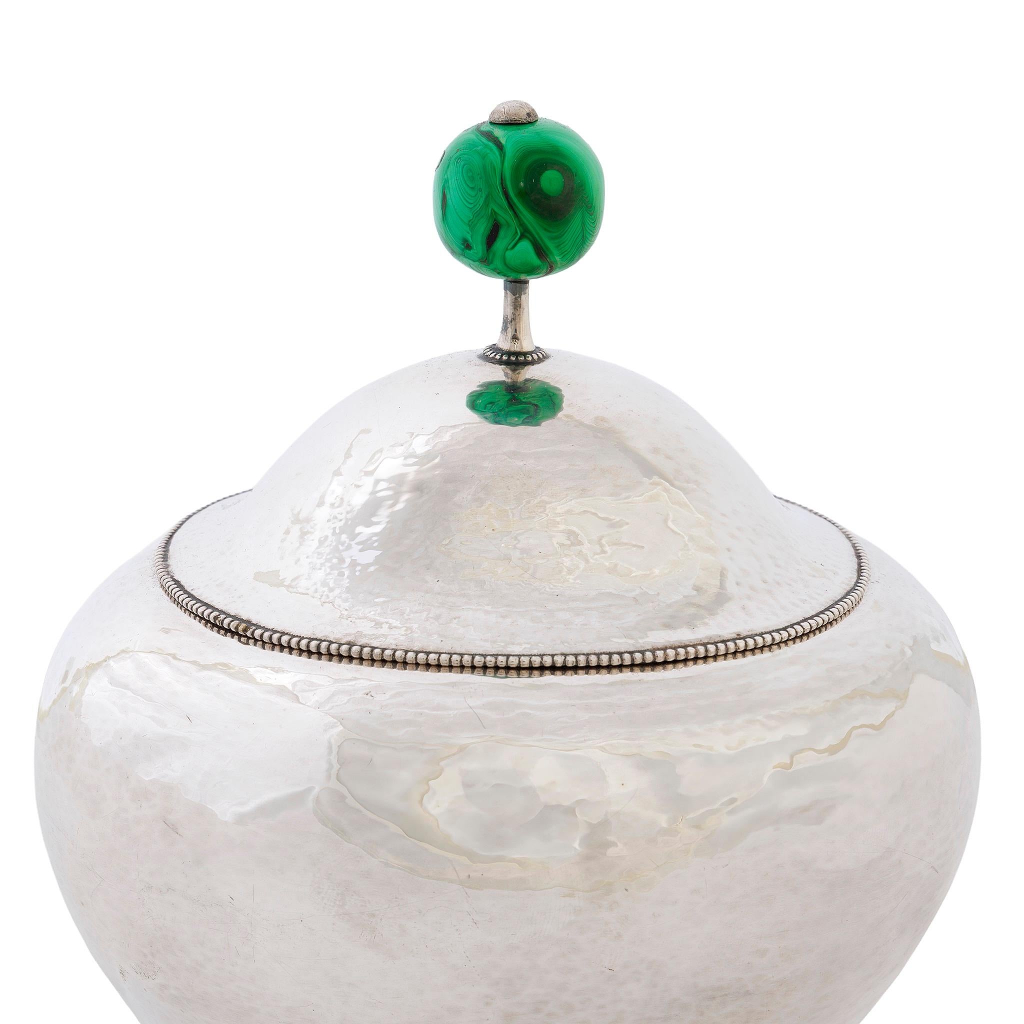 La ciotola coperta di Hoffmann è una sintesi sorprendente del design egiziano, cinese e medievale europeo. Il suo coperchio, con un profilo conico arrotondato e un finale in malachite cabochon, si ispira ai cappelli mandarini della dinastia Qing.