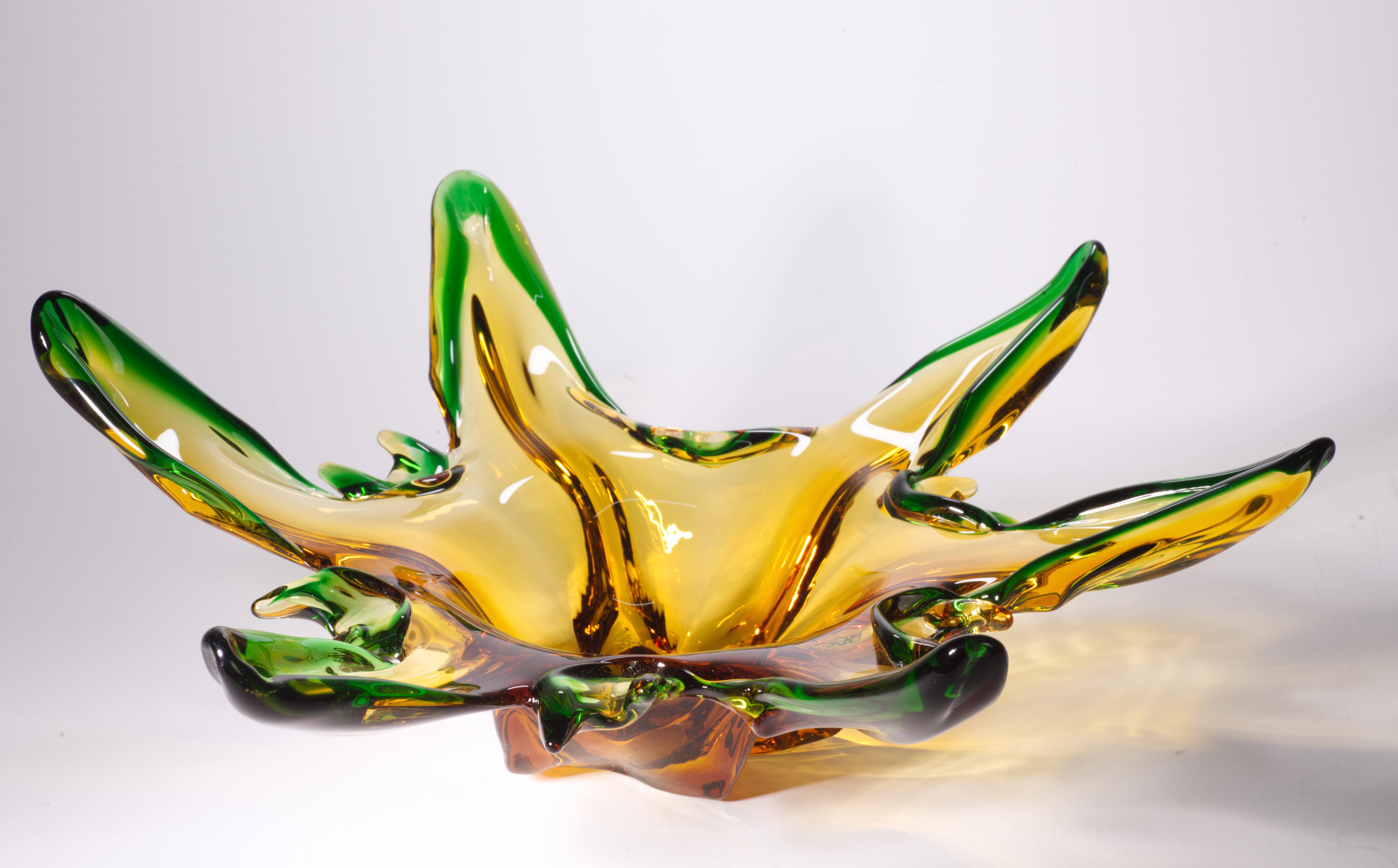  L'étonnante coupe sculpturale sur pied au bord tiré et manipulé présente un changement de couleur de l'ambre au vert profond sur le bord ; le bord asymétrique et fluide crée une ambiance organique et guide l'œil le long de la pièce. Le bol n'a pas