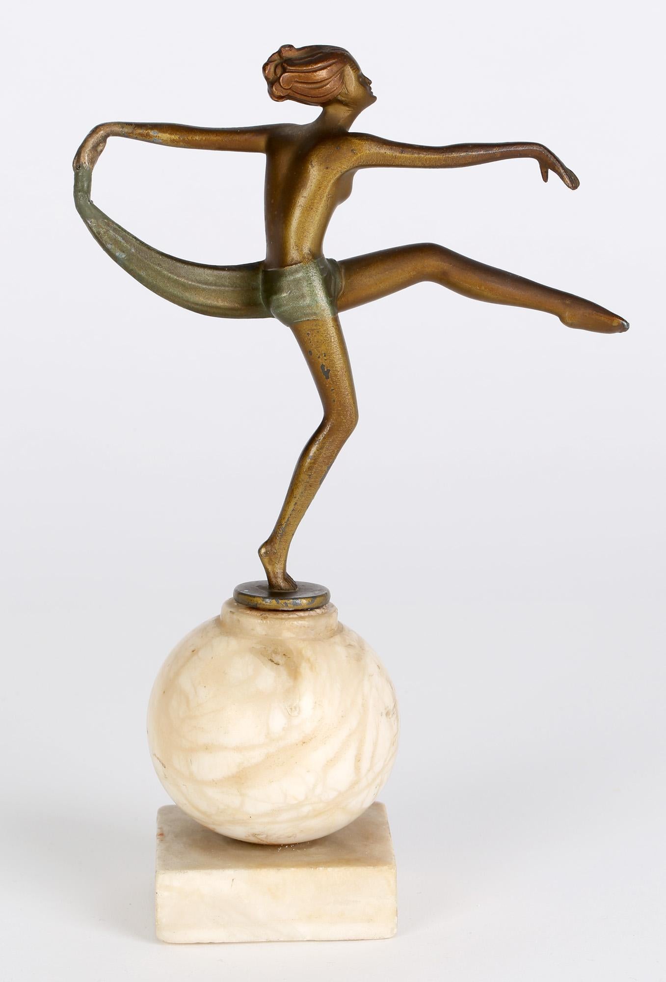 A stylish Art Deco cold painted figure of a dancer mounted on a marble ball shaped base attributed to Josef Lorenzl and dating from around 1930. The figure probably made from spelter is cold painted in a golden bronze color with a green colored