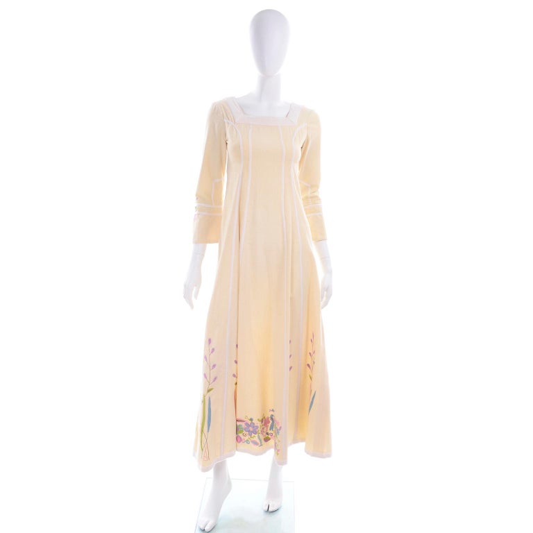 This is a cream heavy weight cotton dress with hand embroidered flowers and birds in shades of pink, purple, blue, lime green, tan. This unlabeled Josefa dress has with white velvet sewn in ribbon trim down the length of the dress and around the