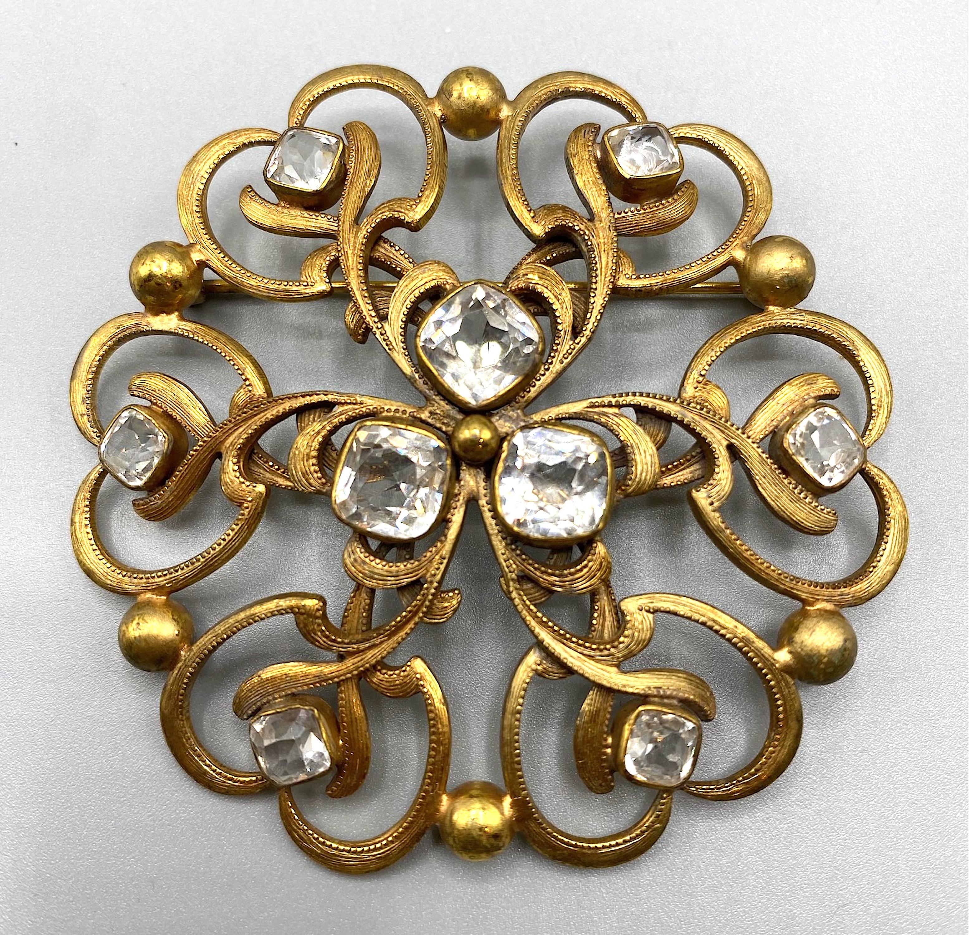 A very nice Joseff of Hollywood  signature round  open work Russian gold and cushion cut crystal brooch circa 1940's.
Joseff of Hollywood was a jewelry firm founded by Eugene Joseff. The firm was particularly noted for creating costume jewelry for