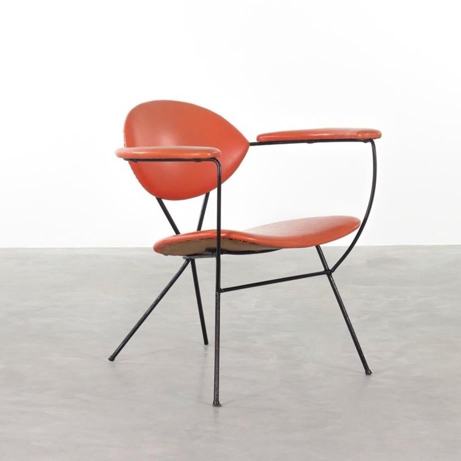 Elegant sculpted armchair designed by Joseph Cicchelli and manufactured by Reilly-Wolff in the sixties. Minimalist black enameled steel frame with red vinyl upholstered seat, back and arm rests all in very good original condition.