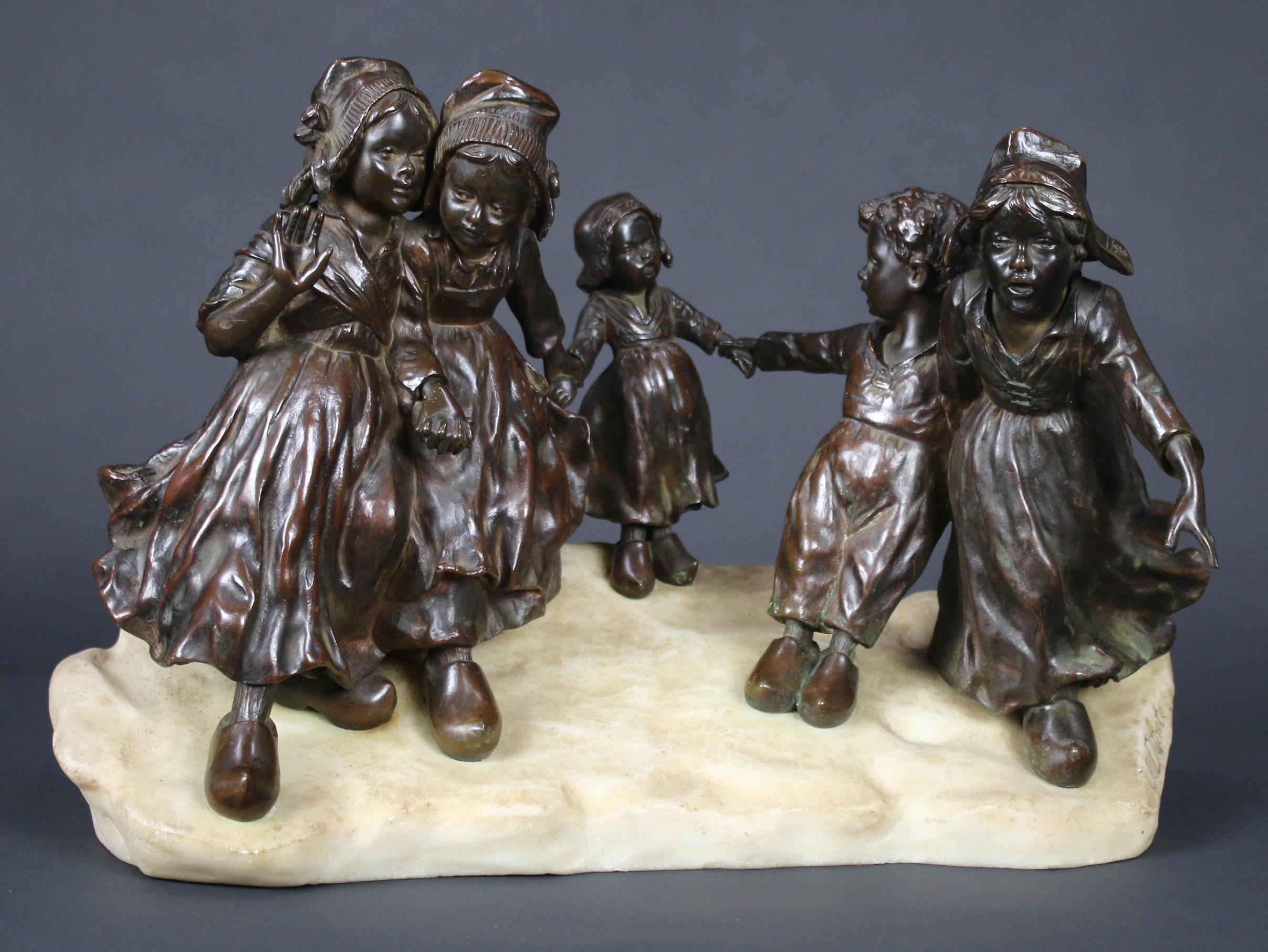 Joseph D'Aste bronze group of Children in traditional dress with clogs playing in the snow, standing on marble.
