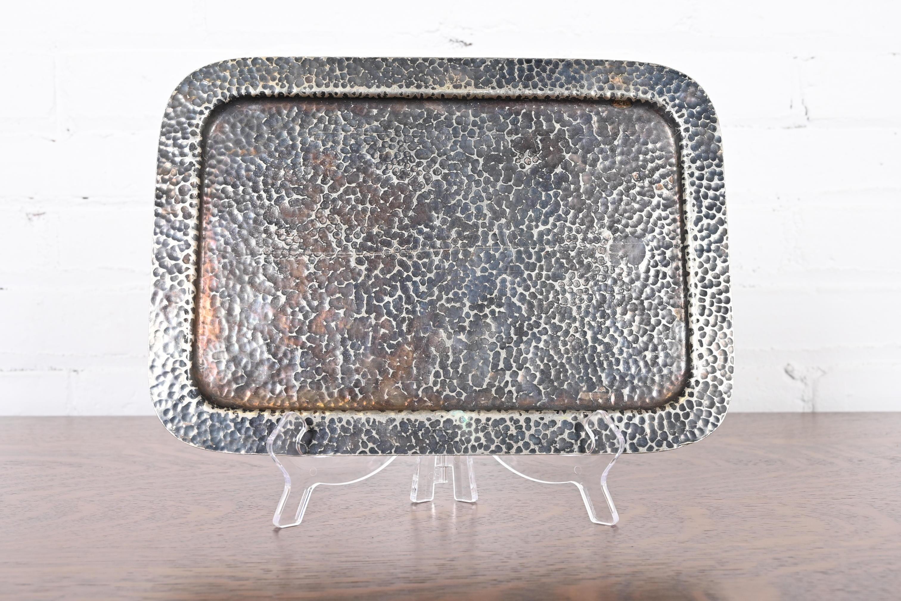 Preciosa bandeja para bebidas de plata martillada a mano de la época Arts & Crafts

Por Joseph Heinrichs

EE.UU., principios del siglo XX

Medidas: 12,13