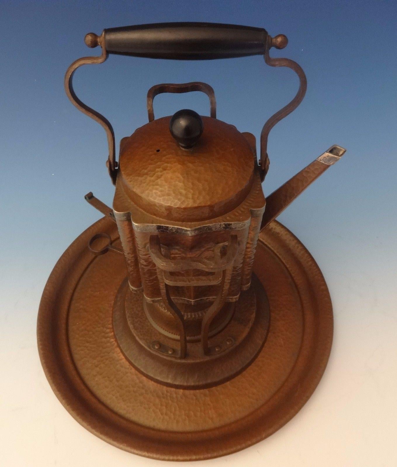 Joseph Heinrichs Arts & Crafts kettle on stand and tray was handmade by Joseph Heinrichs. The piece is made of copper and with applied sterling silver, it's hand-hammered, and it dates from circa 1905. The measurements for the piece are 13 x 8. It