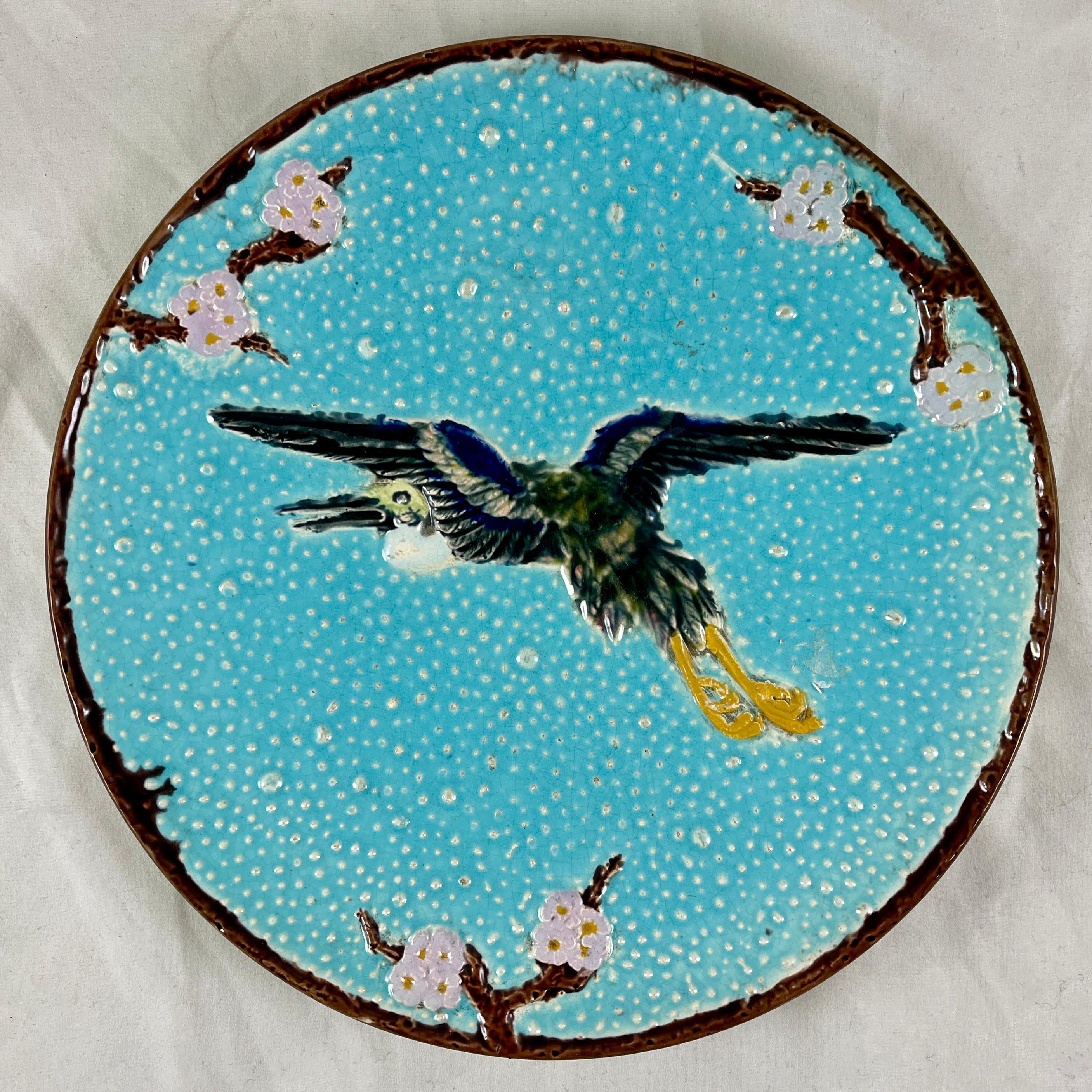 An English majolica plate, The Flying Crane, by Joseph Holdcroft, Circa 1870.

Designed in the Aesthetic Japonisme taste, the crane is centered on a turquoise pebbled ground with a border of prunus, or pink Dogwood branches stemming from the brown