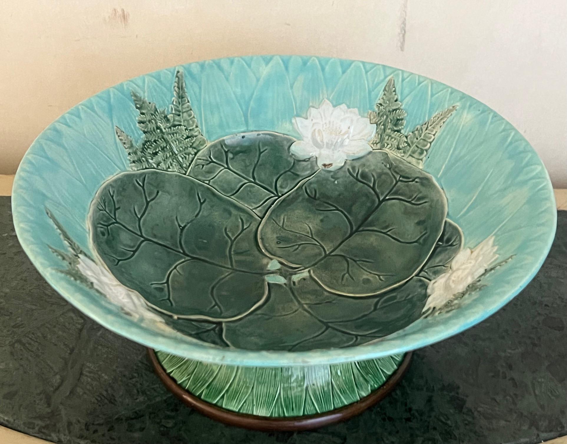 Bol à pied en majolique du 19e siècle fabriqué en Angleterre par Joseph Holdcroft.  La base du bol est recouverte de feuilles de roseau vertes et de feuilles de nénuphar au centre, sur un fond turquoise avec des feuilles de fougère et des fleurs