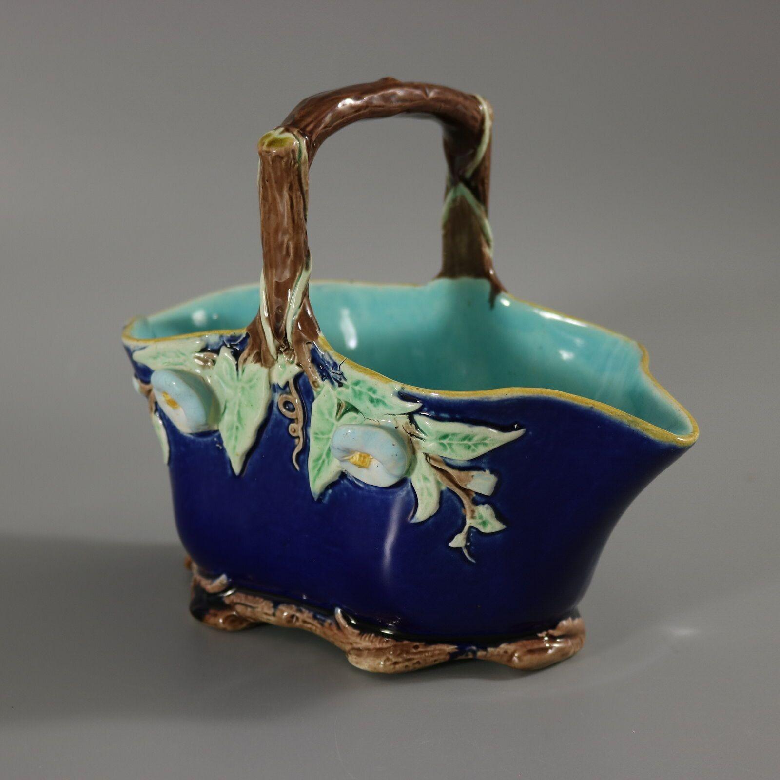 Holdcroft Majolica basket which features flowers and leaves hanging from the branch-like handle. Cobalt blue ground version. Colouration: cobalt blue, green, brown, are predominant. The piece bears maker's marks for the Holdcroft pottery.