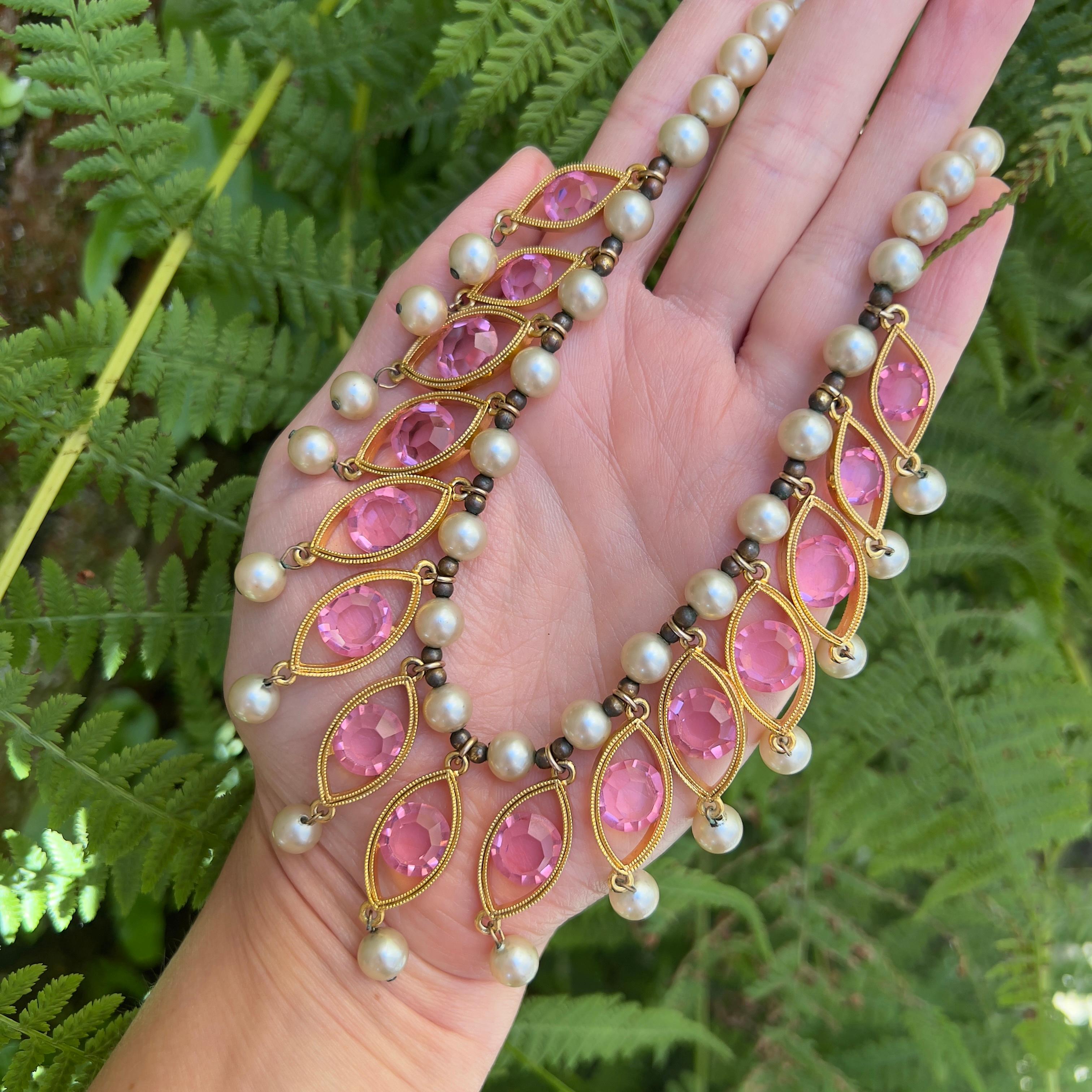 This beautiful necklace exemplifies the fine craftsmanship and intricate designs of Joseph Mazer. It dates from c.1950. 

Condition Report:
Excellent

The Details...
This necklace features a string of faux pearls . Suspended from the centre of the