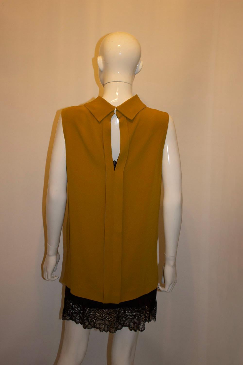 A chic and easy to wear top by Joseph. In a good viscose/acetate mix, the top hangs beautifully. It has a rollover collar, and elegant gap at the back. It has a 3'' slit at the front and 5'' slit at the back . ie it is longer at the back. 
Size 42
