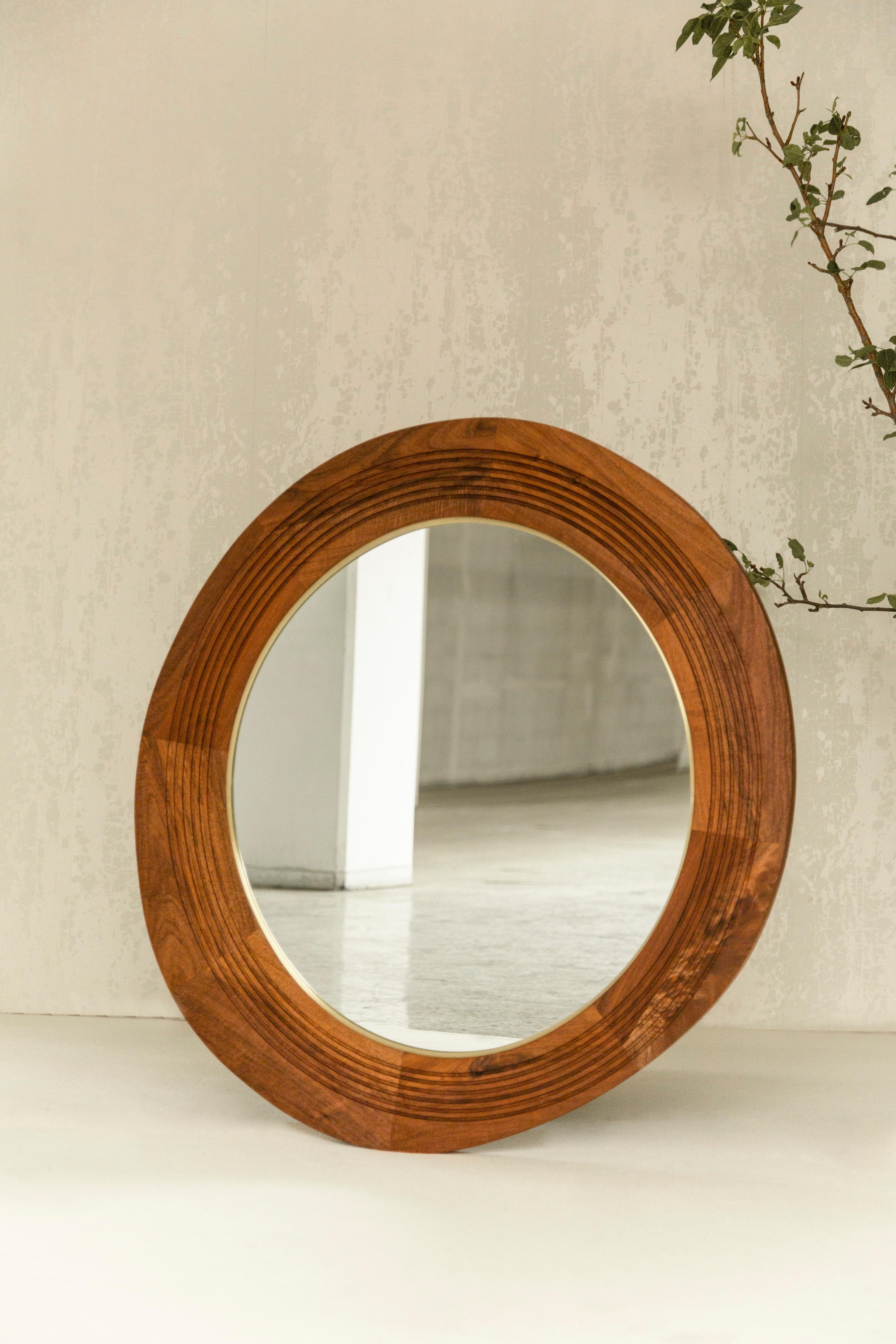 Der Joseph-Spiegel ist ein großartiger Akzent, der jede Wand schmückt. Die asymmetrische ovale Form des Rahmens erzeugt eine interessante Spannung und einen Kontrast zu dem symmetrischen ovalen Messingring und dem Spiegel. Der Spiegel hat
