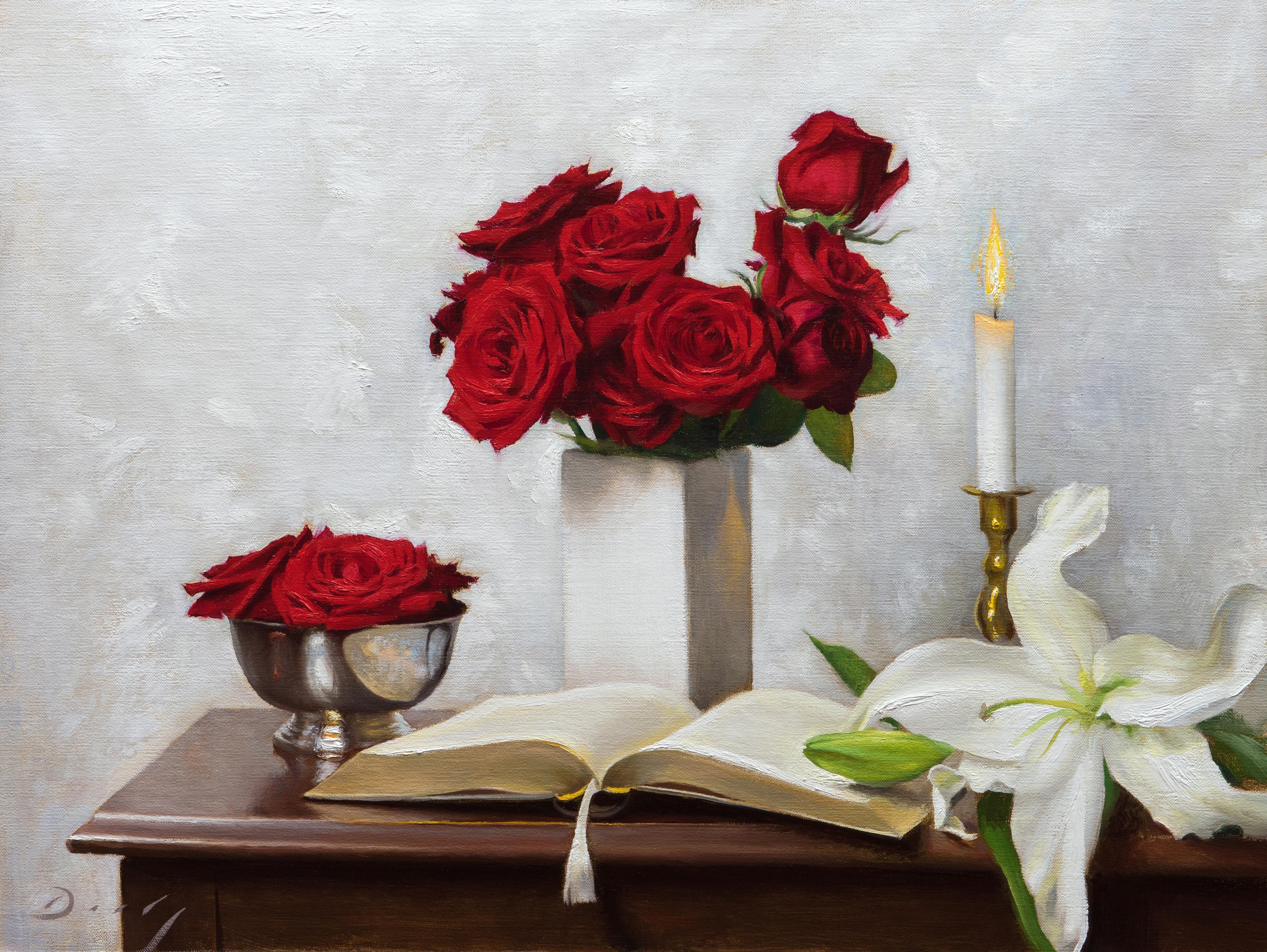 Bouquets of red roses sit on a wooden desk in After the Festival.  A book is left open on the desk while a lit candle flickers in the background. The warm glow from the candle light reflects off of the vase and illuminates the scene. A single white