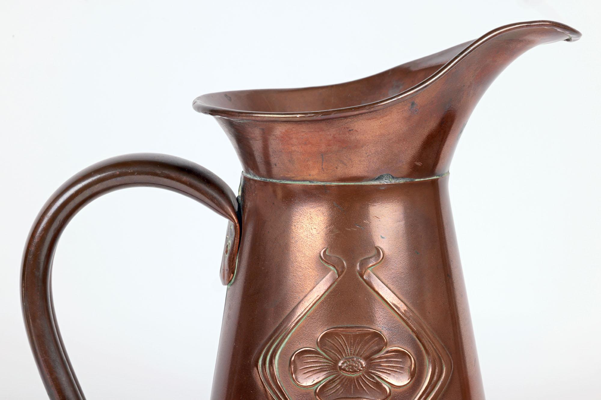 A stylish English Art Nouveau large copper pitcher decorated in a stylized floral pattern by renowned Bilston based metalworkers Joseph Sankey & Sons dating from around 1900. The large and tall copper pitcher has a trumpet shaped body embossed with