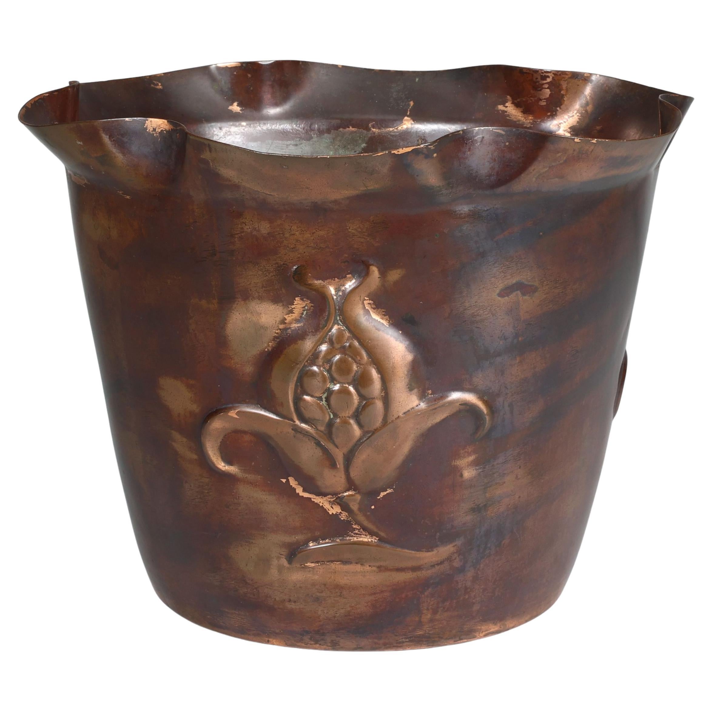 Joseph Sankey & Sons. An Arts & Crafts copper planter with embossed flower pod