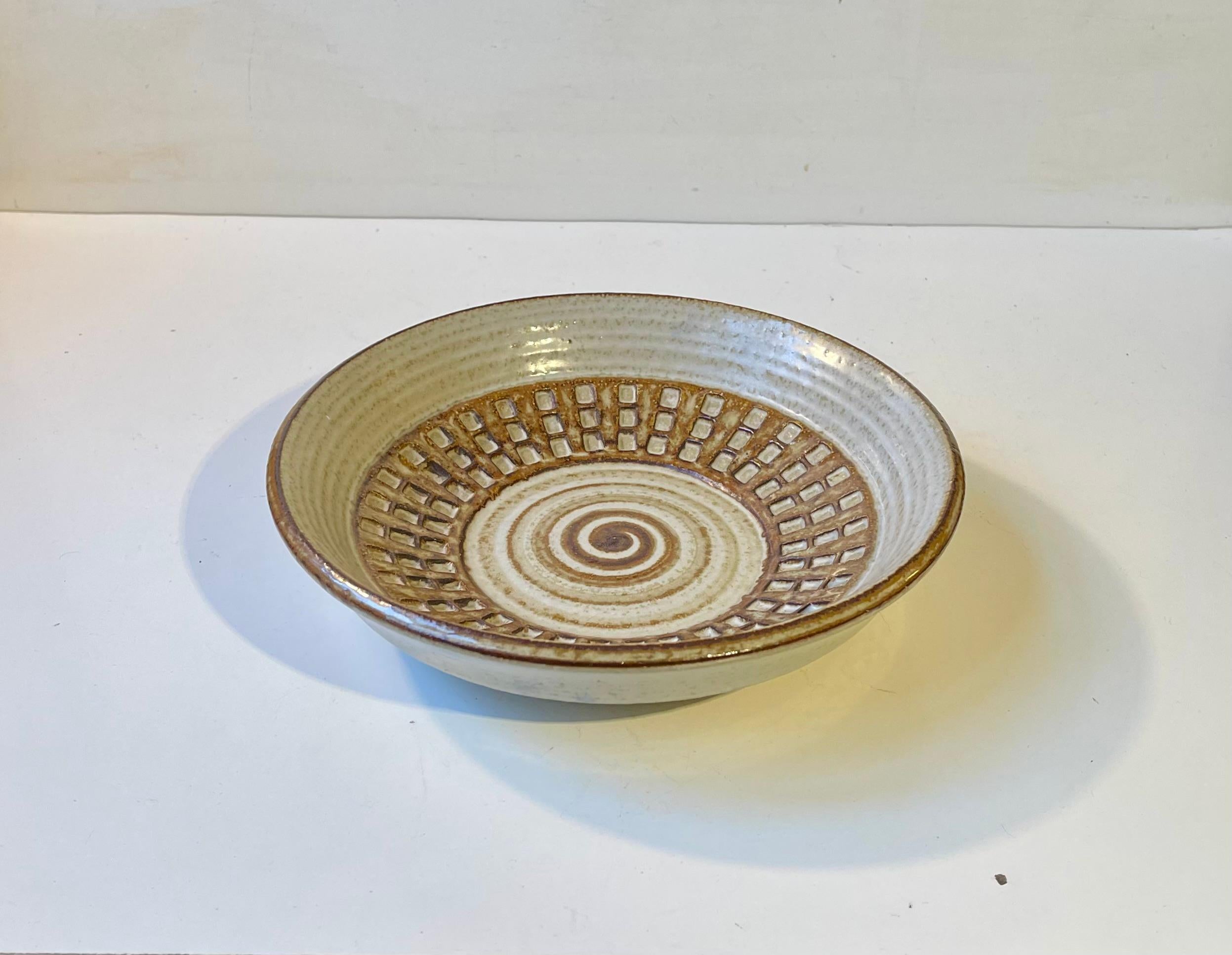Ciotola in gres fatta a mano. Decorato con smalto al caffè con motivi a rilievo di spirali e quadrati. Disegnata dal ceramista Joseph Simon e realizzata a Søholm in Danimarca tra il 1967 e il 1969. Numero design: 3259 - fatto a mano. 

Misure: D: