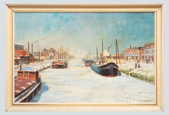 Charming Belgian scene with canal frozen with boats industrial town