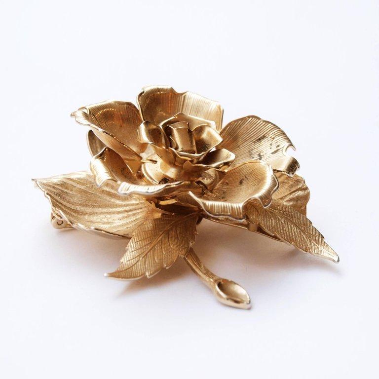 Known as the 'day to night' brooch, the rose closes and opens by moving the right lower left leaf. Designed by Joseph Warner who was known for his high quality jewelry. 
This mechanical brooch that has been featured in 