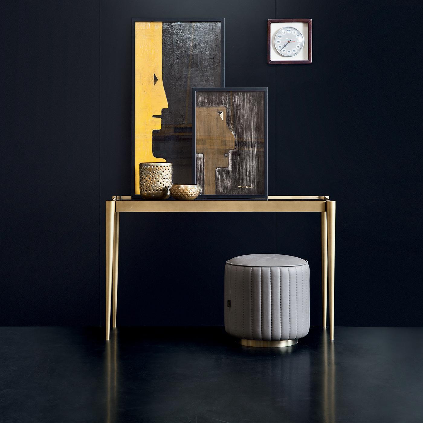 A simple, Minimalist design transforms this console in an extremely functional and versatile piece of decor. The rectangular stainless steel structure has a polished brushed brass finish and features four long tapered legs encased in a frame