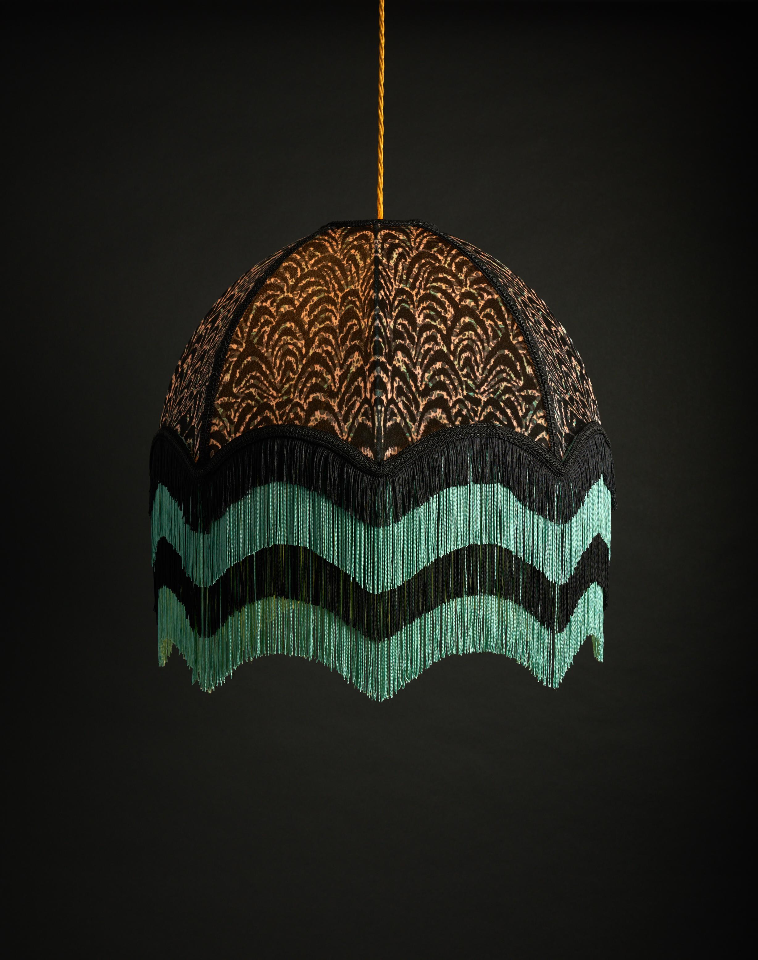 Josephine is an ink painted print with a deco edge. With hints of turquoise, pink and cream this design is shown off beautifully by the four layers of sea green and black alternating fringe.

Anna Hayman lampshades create a fantastic centrepiece to