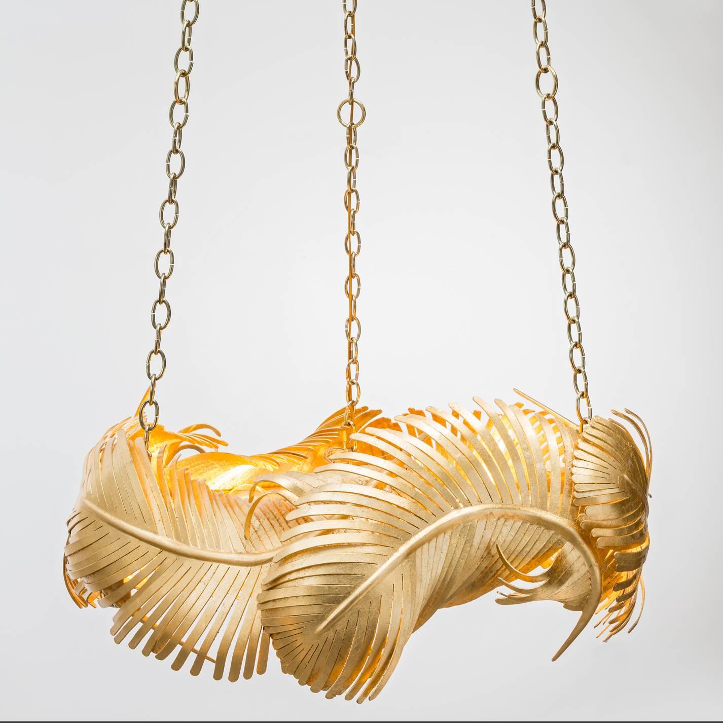 The Josette chandelier is a sculptural fete featuring hand-forged gold leaf over iron feathers suspending from custom brass poles. Light bulbs: Eight clear globe g25 standard base 60 watt max (not included). This is a showroom sample sold as is. CSA