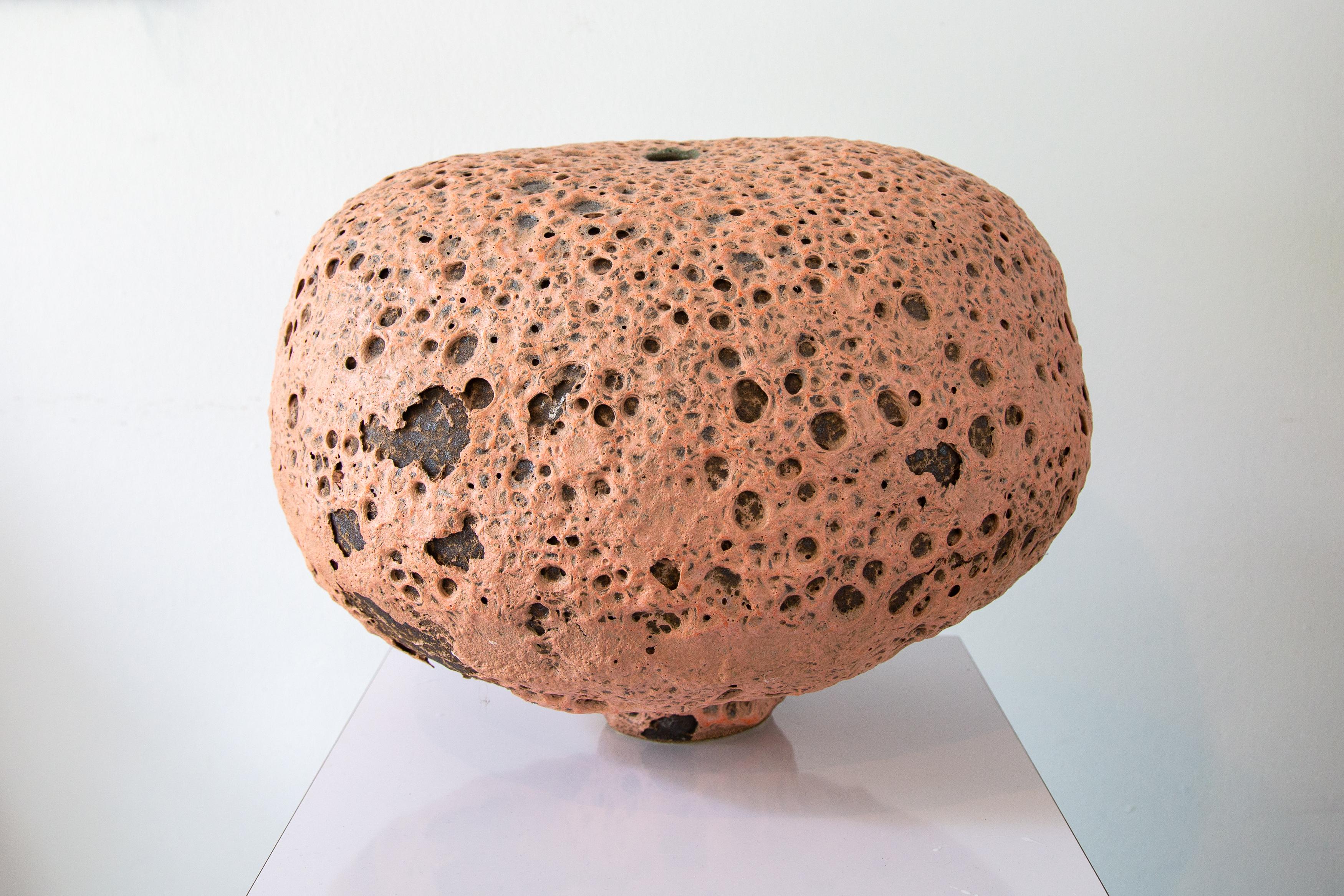 An early work by Josh Herman, showcasing a crater like volcanic salmon pink colored vase. This is a super early example and considered part of his experimental phase where josh was testing glazes and adherence. This was purchased directly from Josh