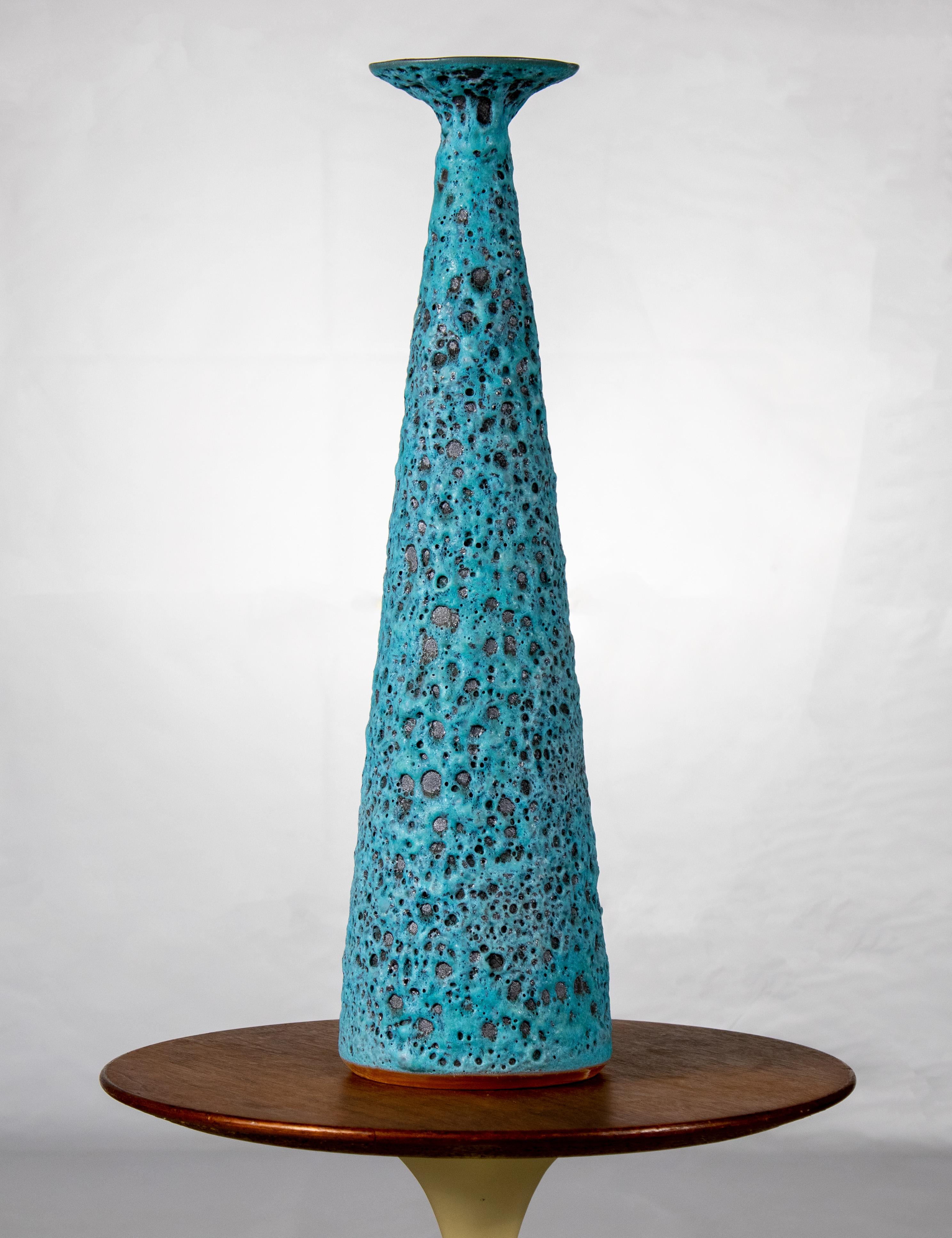 Une des premières œuvres de Josh Herman, qui présente une glaçure turquoise volcanique semblable à celle d'un cratère. Cet exemple est le premier d'une série de vases en forme de trompette. Il s'agit d'une présence importante, d'une hauteur de 23
