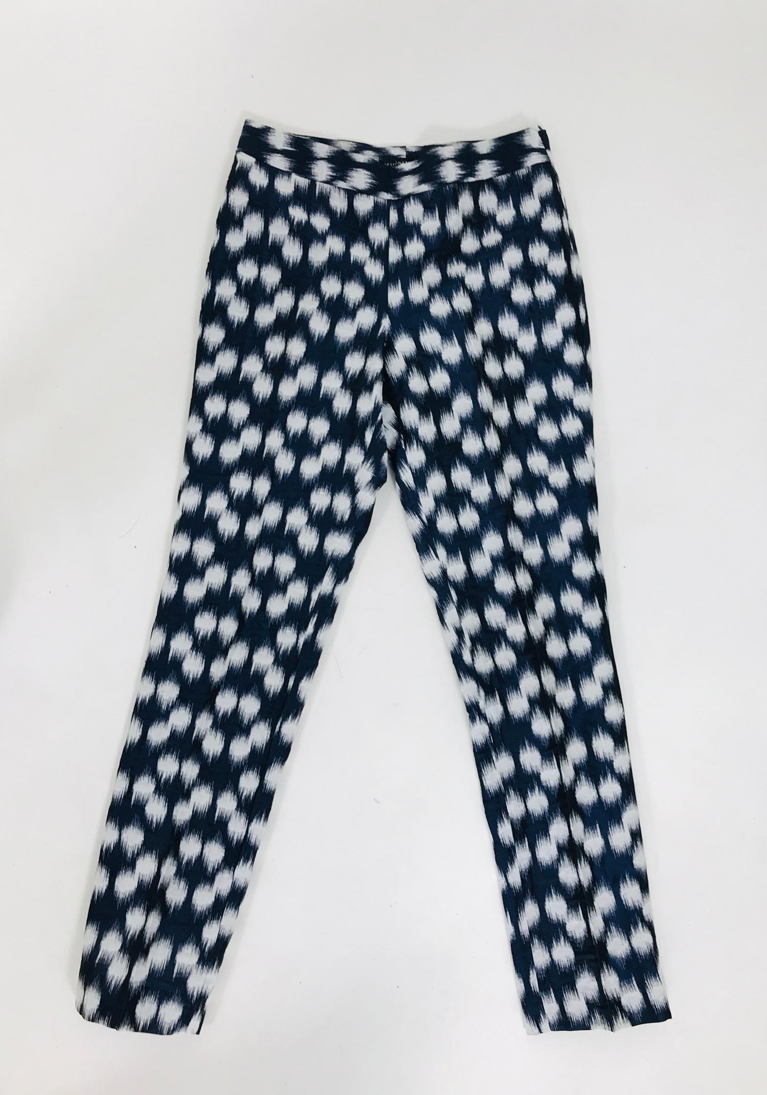 Jose Natori Ikat woven cotton blend trouser with a silky finish, in dark blue, black, metallic thread and white. flat front band waist trouser closes at the side with a zipper and hidden hook & eye. Tapered legs. Unlined. Marked size 2. 
In