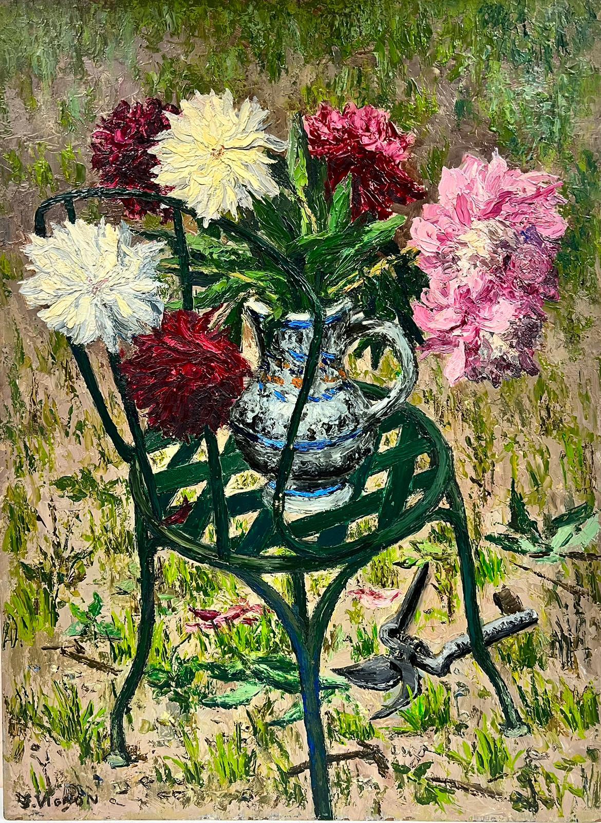 Des fleurs enflammées dans un vase reposant sur une chaise de jardin verte épaisse 