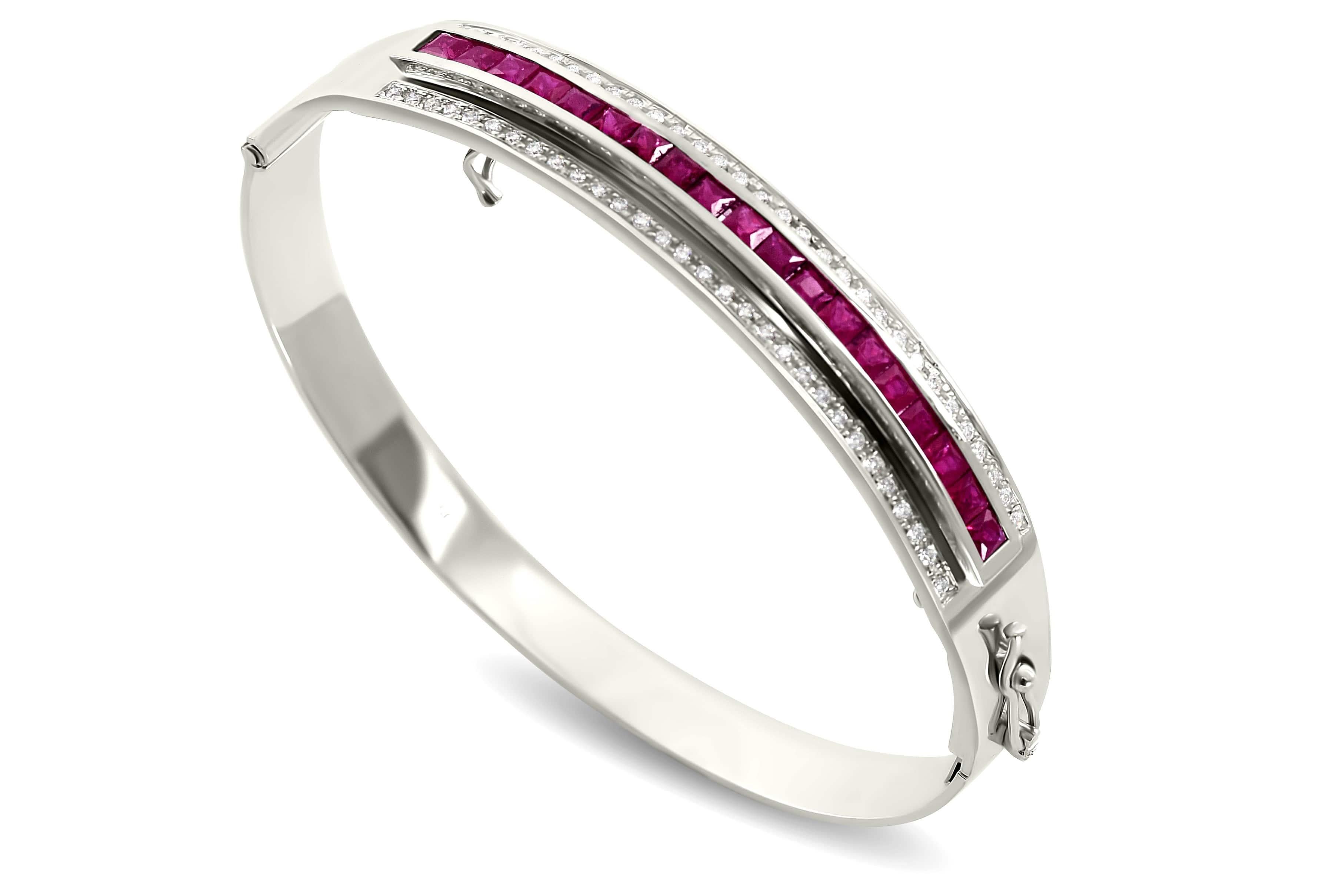 This decadent piece features the highest quality brilliant cut diamonds set in solid platinum in an elegant hinged oval bangle. The featured gemstone insert is interchangeable, set with magnificent hand selected, calibrated rubies, tsavorites and