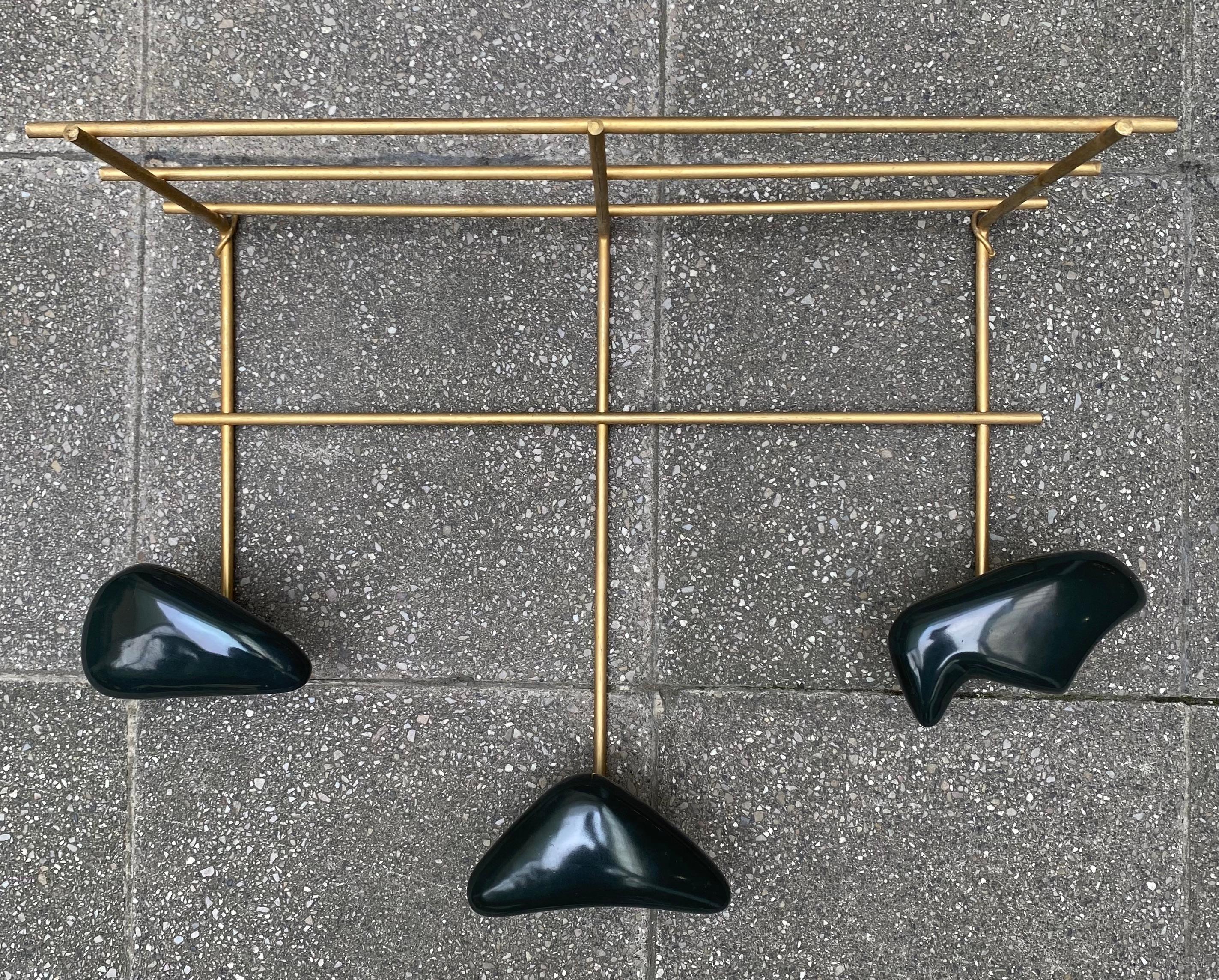 JOUVE - COAT RACK
Georges JOUVE (1910-1964) for Marcel ASSELBUR (1910-1964)
Wall coat rack with three hooks, circa 1955.
Golden brass and black ceramic.
36 x 49.5 x 22cm
In very good condition

Who is Georges Jouve?
Georges Jouve is a French
