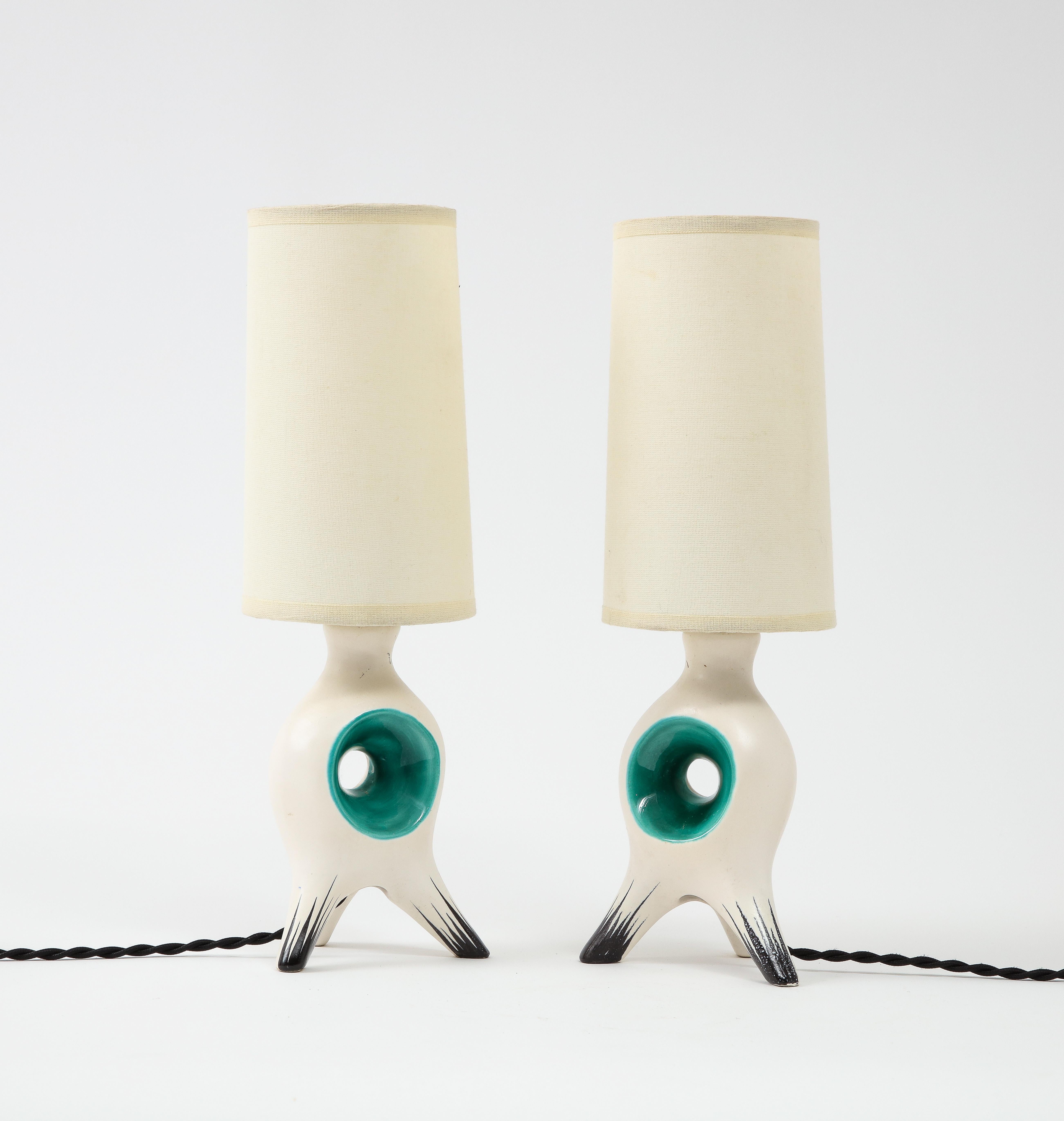 Whimsical table ceramic table lamps in the style of George Jouve, with a soft white glaze and green/black accents. Rewired with silk cords and candelabra sockets. No Shades included. Base only is 9''x5''.