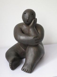 Sentada con la cabeza en la mano