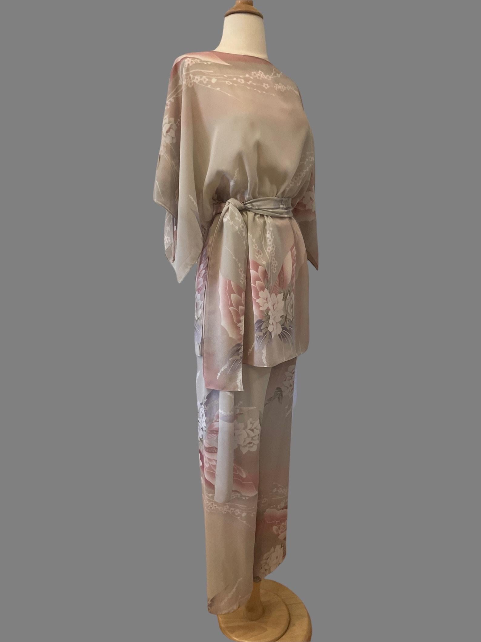 ensemble trois pièces vintage : chemisier, pantalon et ceinture. silhouette fluide et ample. long chemisier tunique avec encolure bateau, taille élastique cintrée et manches d'ange avec ouvertures en trou de serrure avec fermeture à nouer. pantalon