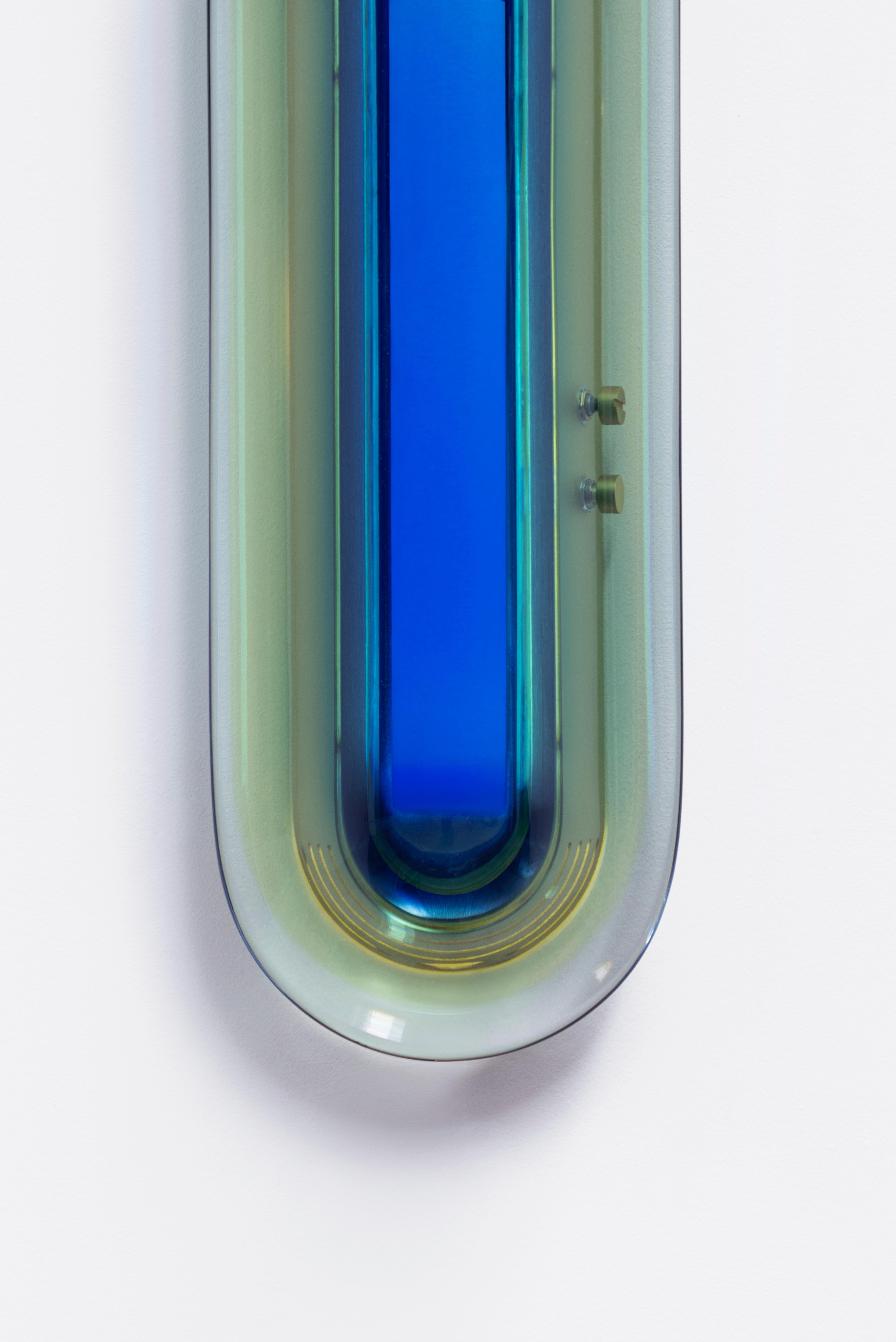 S'inspirant de l'ère spatiale, l'applique Joy apparaît comme une sculpture lumineuse qui attire le regard. Ses couleurs vibrantes sont méticuleusement fabriquées à la main dans notre atelier en superposant de la résine époxy pour obtenir des teintes