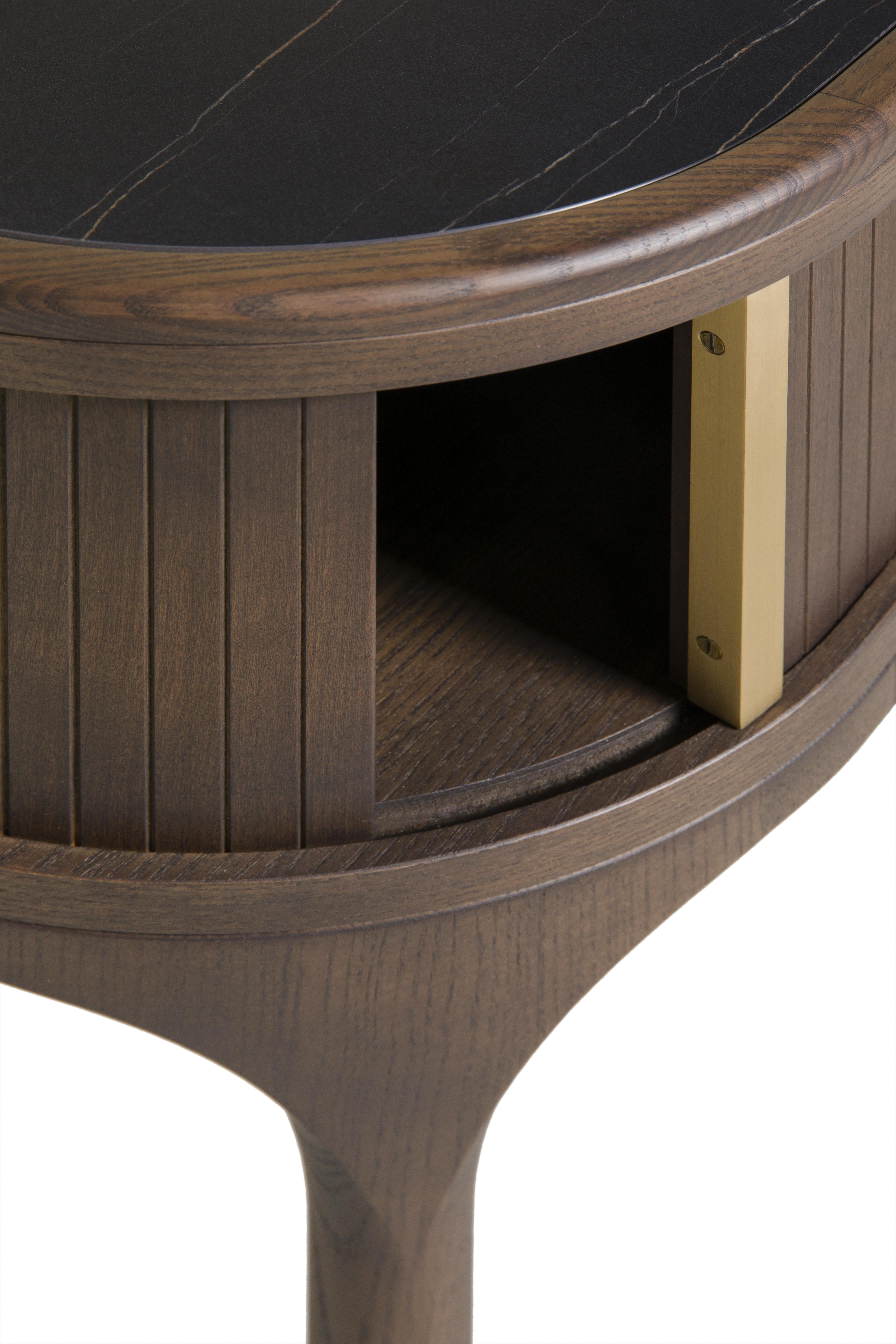 Nachttisch aus Eschenholz mit Glas- oder Marmorplatte, einem durch eine Schiebetür geschlossenen Fach und Messinggriffen. Geformter Fuß mit Messingschale.
Entwurf Libero Rutilo

 