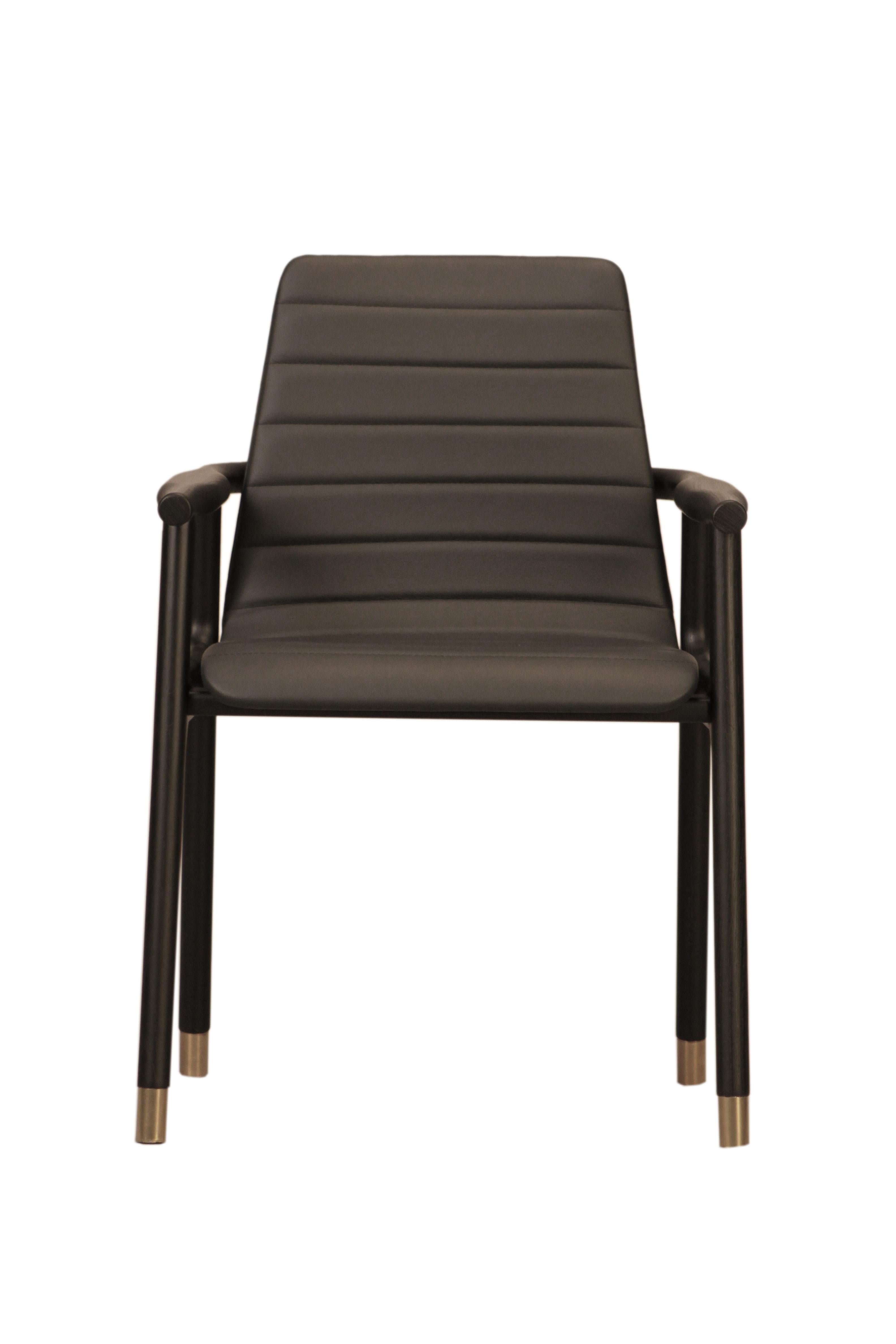 Contemporary style Joyce dining armchair made of ashwood with leather tufted seat and brass tips.
Design Libero Rutilo