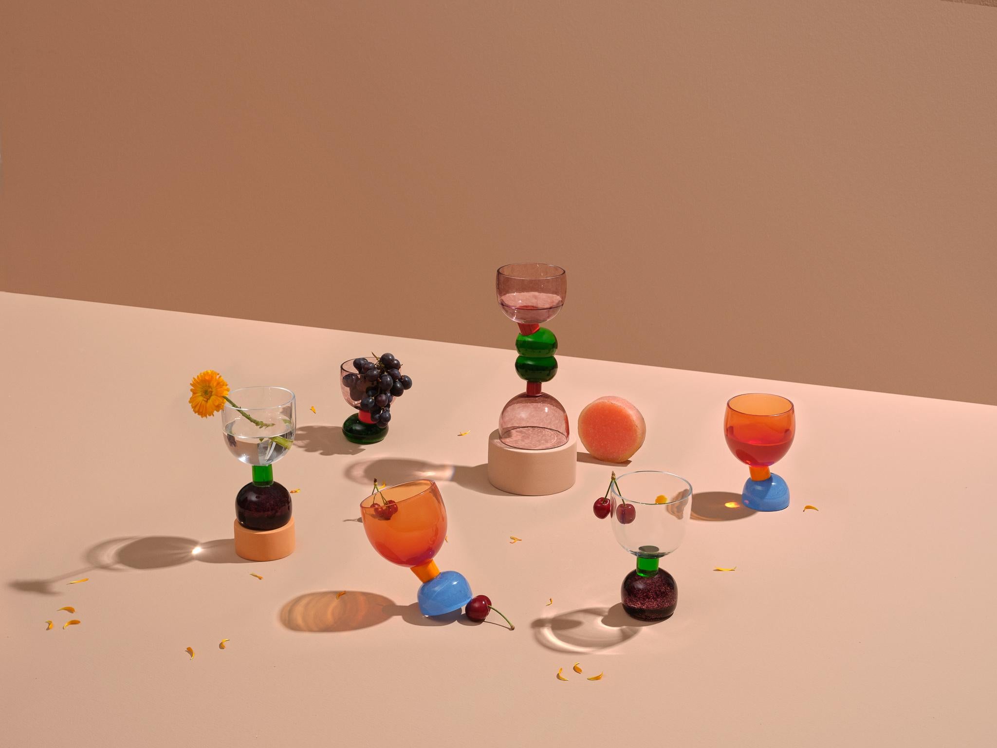Dieses skulpturale Trinkgeschirr ist farbenfroh, naiv und wird unsere Tische schmücken und gleichzeitig funktional sein.
Die Glaswaren spiegeln das Bedürfnis der Designerin wider, sich mit farbenfrohen Materialien und Formen zu umgeben und mit