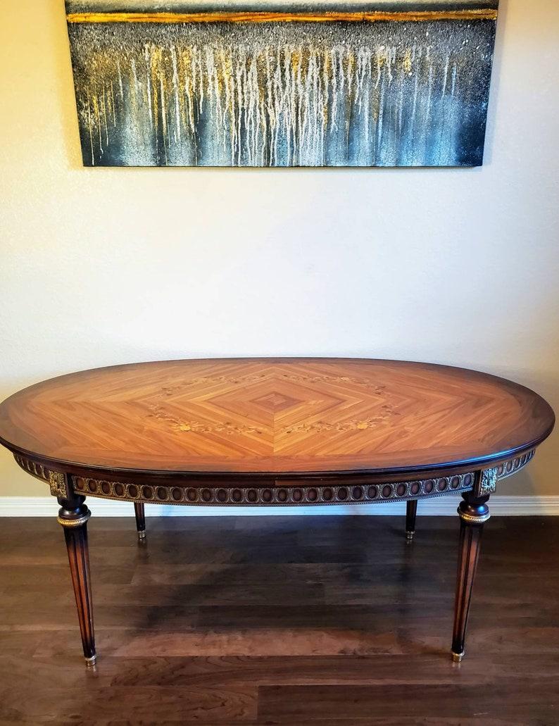 A stunning, fine quality vintage French gilt bronze ormolu mounted marquetry inlaid rosewood extension dining table by J.P. Ehalt.

Exquisitely handcrafted using only the finest materials and highest level of craftsmanship, the mid-century antique