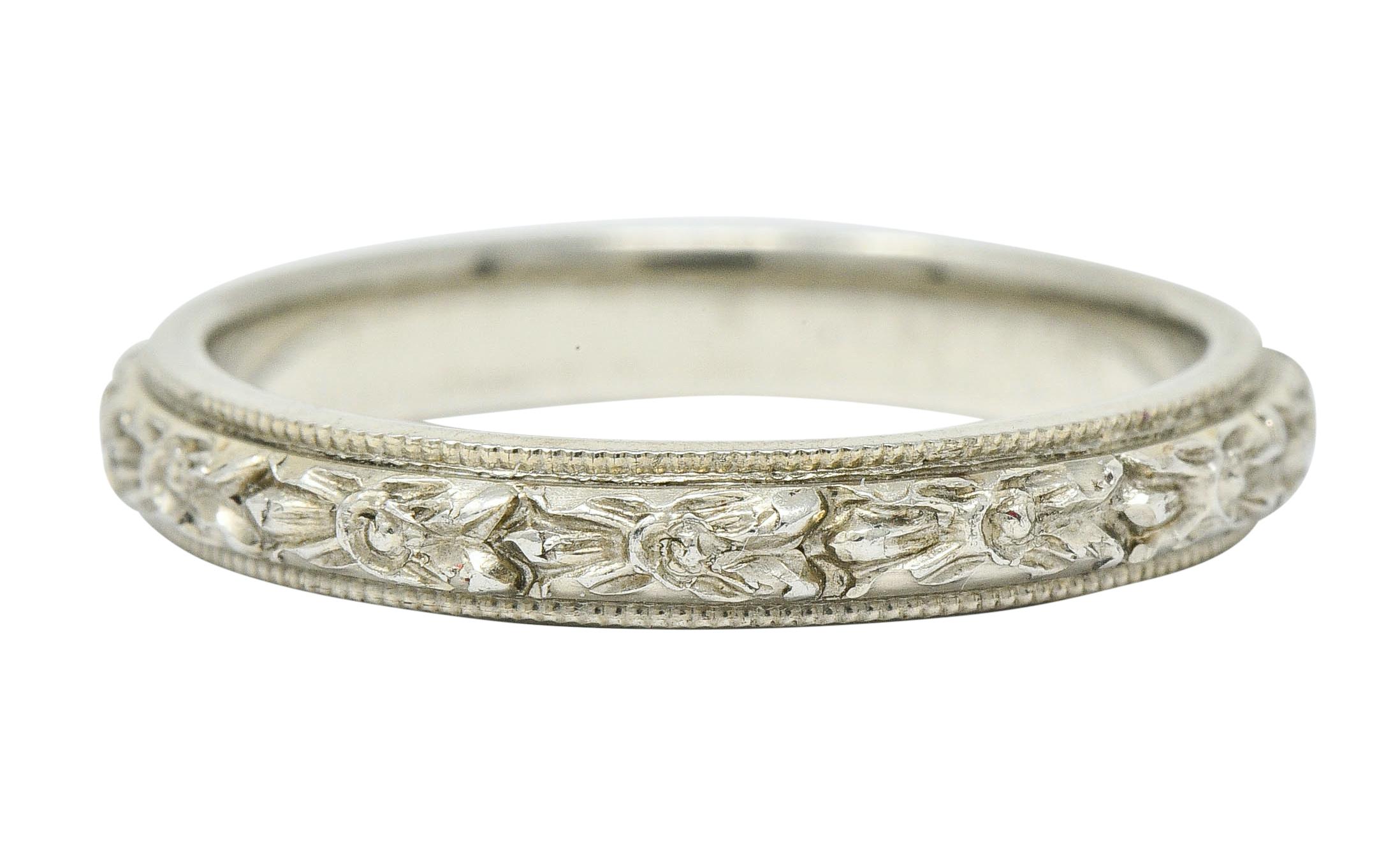 Band style ring with milgrain edges and a deeply engraved center

Featuring highly rendered florals flanked by foliate, repeated fully around

With maker's mark for J.R. Wood & Sons

Stamped 18K for 18 karat gold

Circa: 1930s

Ring Size: 5 & not