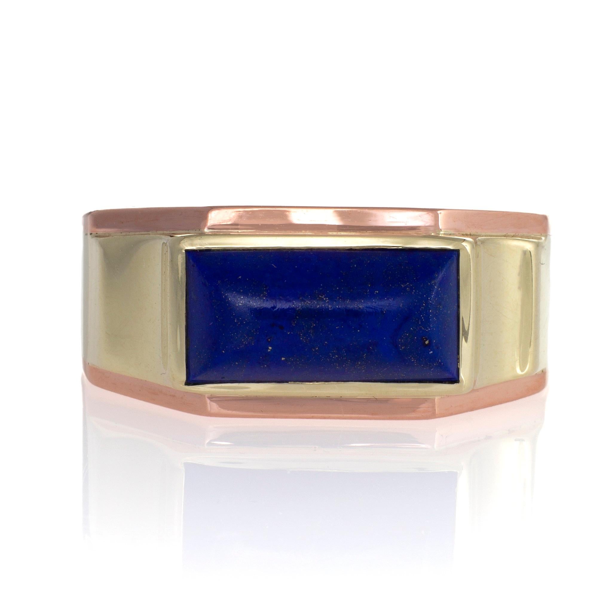 Made by the New York and San Francisco firm J.R. Wood & Sons, this streamlined late Art Deco ring dating from the 1930s is set with a lapis cabochon in bi-color gold. The elongated lapis sugarloaf cabochon is edged by an arched rose gold border, and