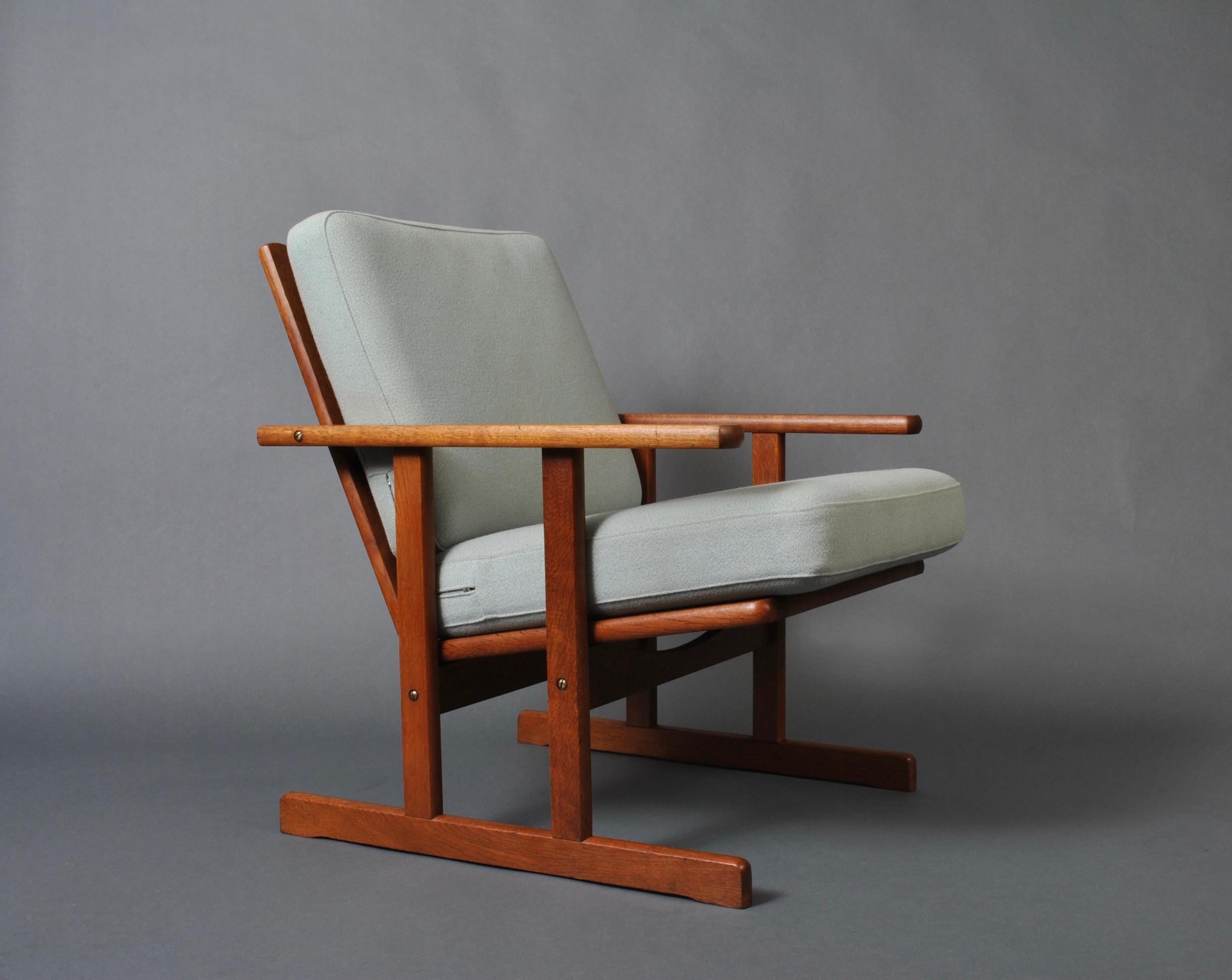 An early production oak armchair designed by Jørgen Baekmark for FDB Møbler. Produced by FDB, circa 1950. Pure minimal Modernism in design with a serious nod to the Mission and Arts & Crafts ethos. A rare midcentury easy chair.
Custom upholstery is