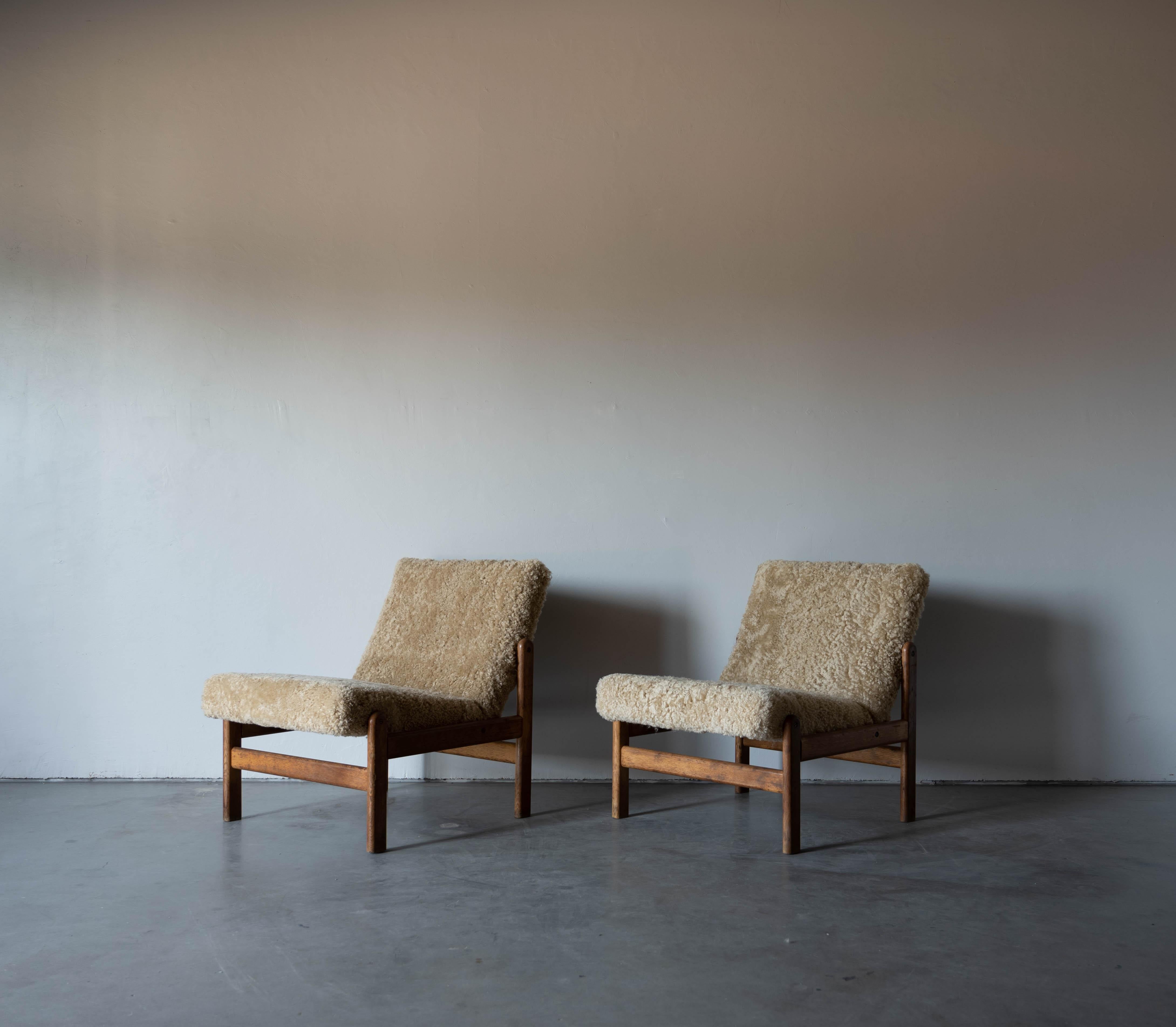 A pair of oak and shearling / sheepskin slipper chairs designed by Jørgen Bækmark for FDB Møbler, Denmark, 1950s. 


