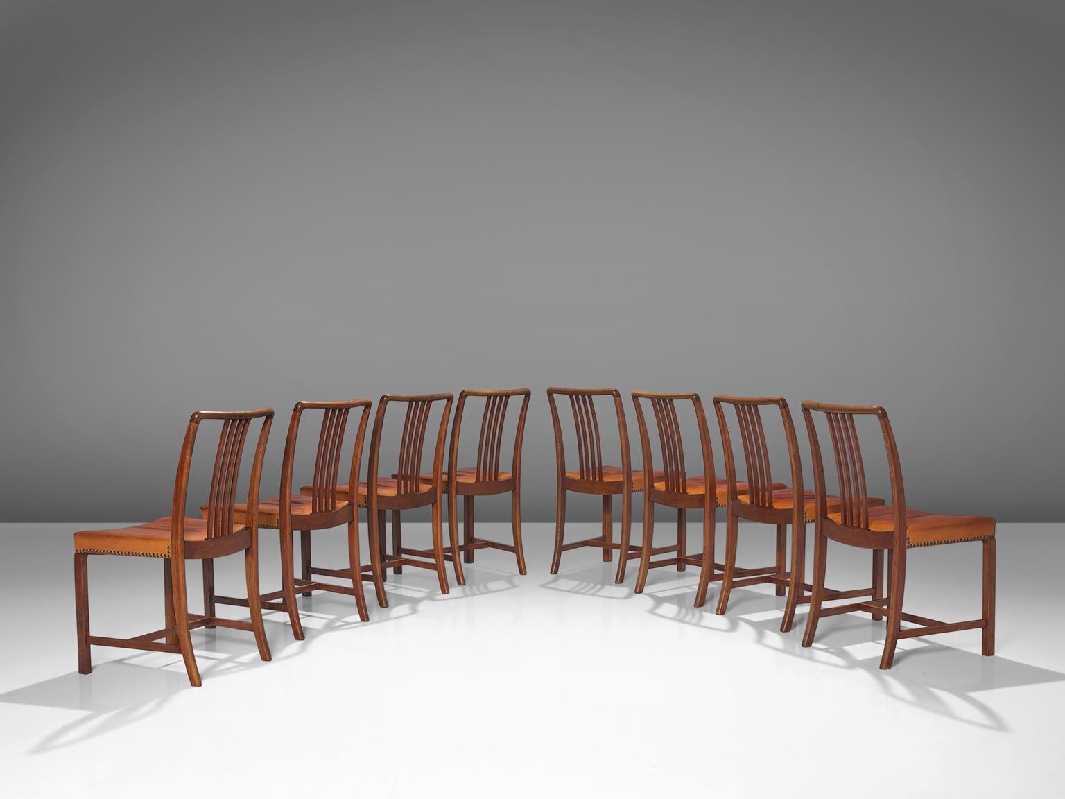 Jørgen Christensens for Jørgen Christensens, set of eight dining chairs, oak, original cognac leather, Denmark, 1942
 
Danish designer and cabinetmaker Jørgen Christensens designed this elegant set of dining chairs in 1942. The dynamic curve in the